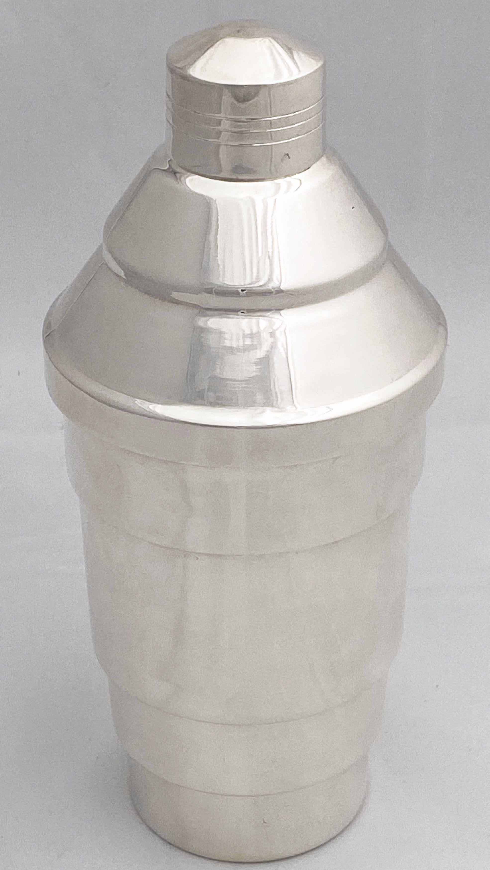 A vintage English cocktail shaker of fine plate silver from the Art Deco period, c.1940, featuring a stepped lid and body and internal ice strainer.