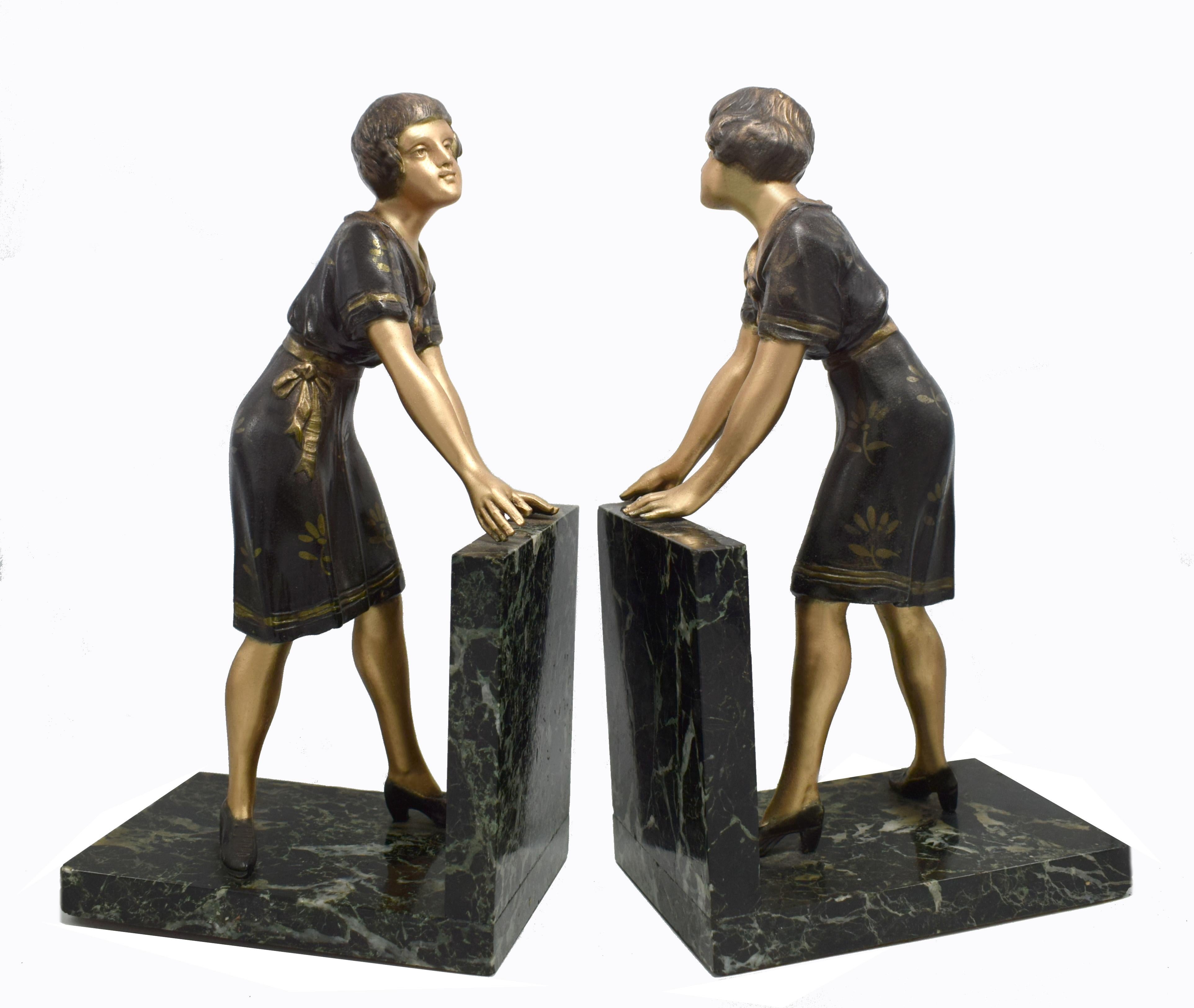 Stylish matching pair of Art Deco figural bookends dating to the 1930s. Originating from France the figures are made from cold painted spelter and rest on solid marble plinths. Dressed in the fashion of the day with curled bob hair cuts, little