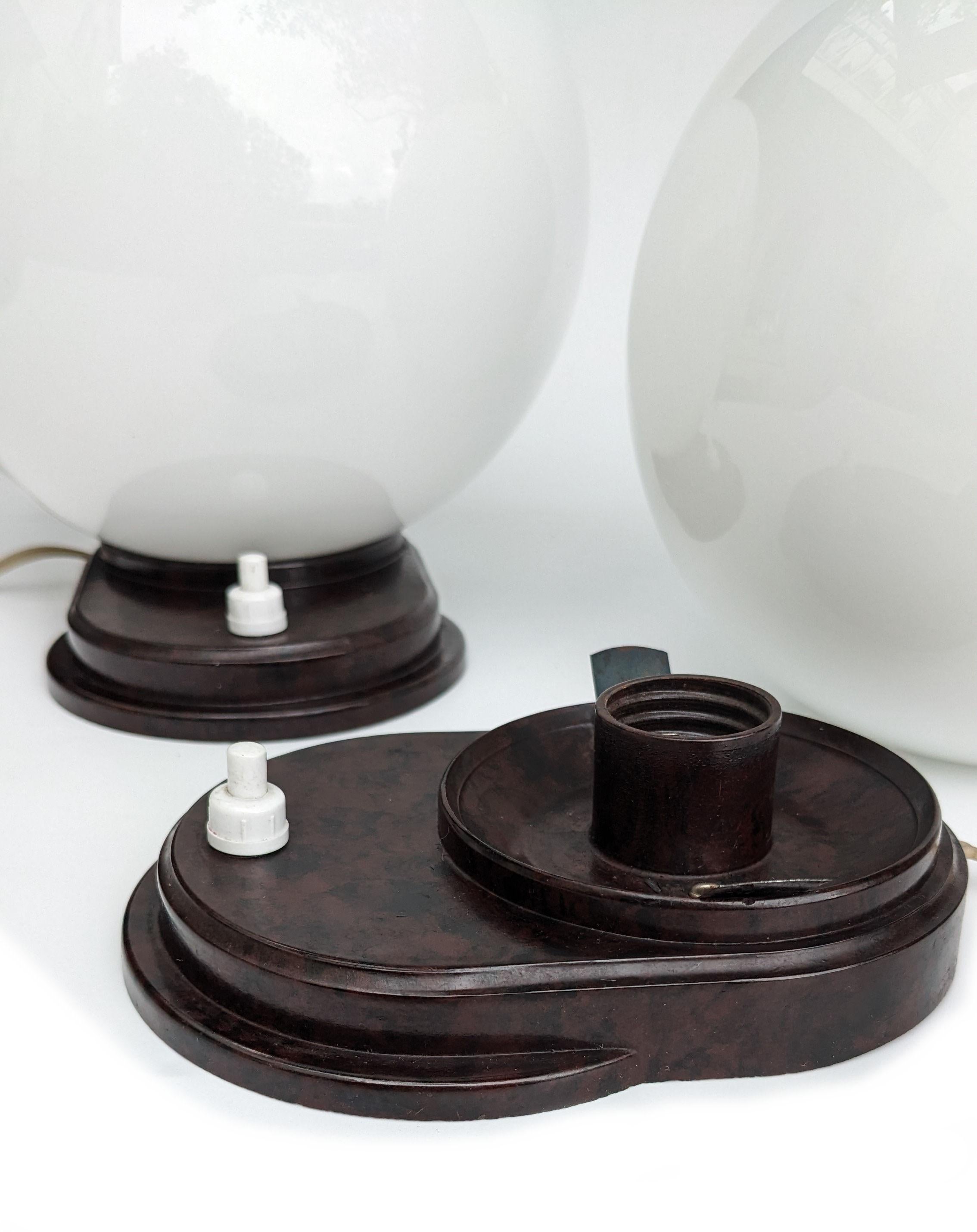 For your consideration are these original matching pair of Modernist table lamps dating to the 1930s. Both have mottled streamline bakelite bases which supports a large milk glass globe shade. They are both in excellent condition with no damages