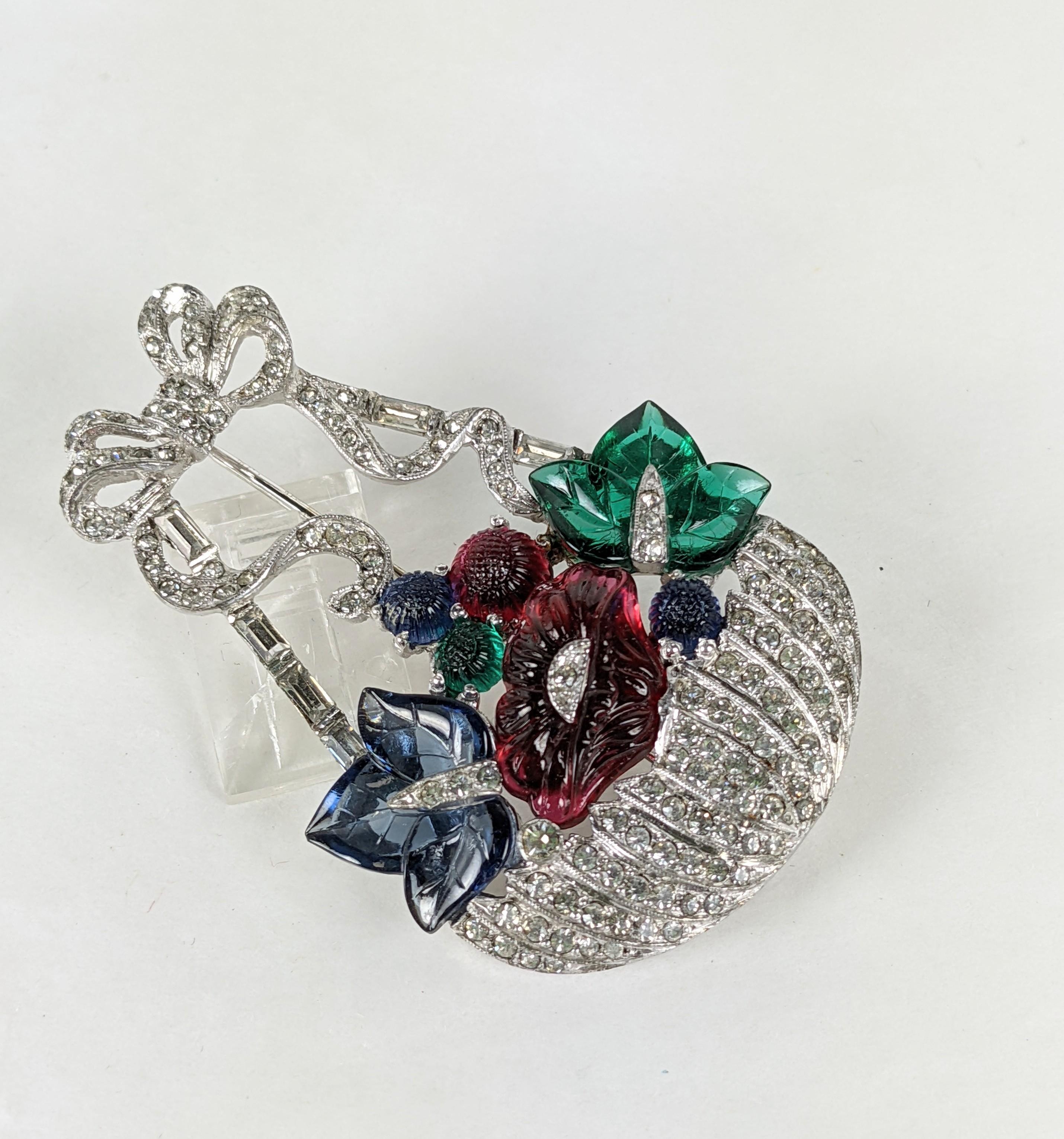 Mazer rare Art Deco brooch of pave and tricolor fruit salad stones. The openwork flower baskets' handle wrapped by an unfurling bow. The brooch of rhodium plate base metal, crystal rhinestone pave, molded fruit salad flowers, round buds, and pointed