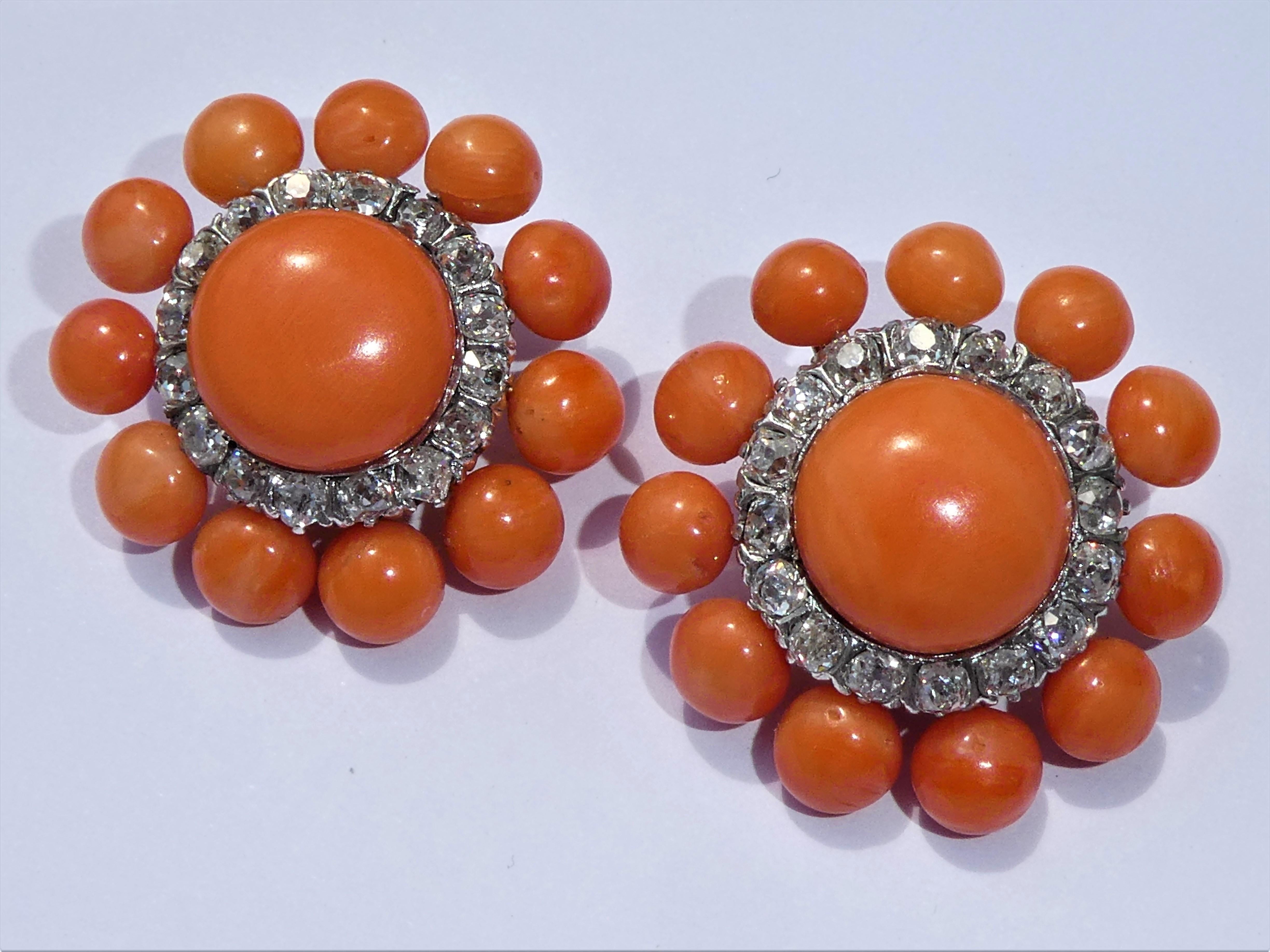 The design of the red coral earclips is like a sun or a flower. They were beautifully crafted in Europe in 14 karat yellow gold around 1920 with red coral cabochons and are gorgous on. Accentuating the large central coral are 16 diamonds of high