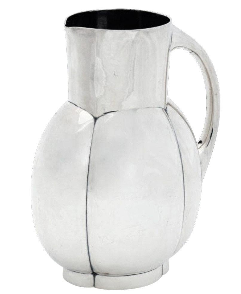 Elegant Art Deco pitcher shaped with melon-style ribs on a quatrefoil base designed by Christian Fjerdingstad who was a Danish sculptor born in 1891. When he came to France, he created some gorgeous pieces for Gallia and some were edited by