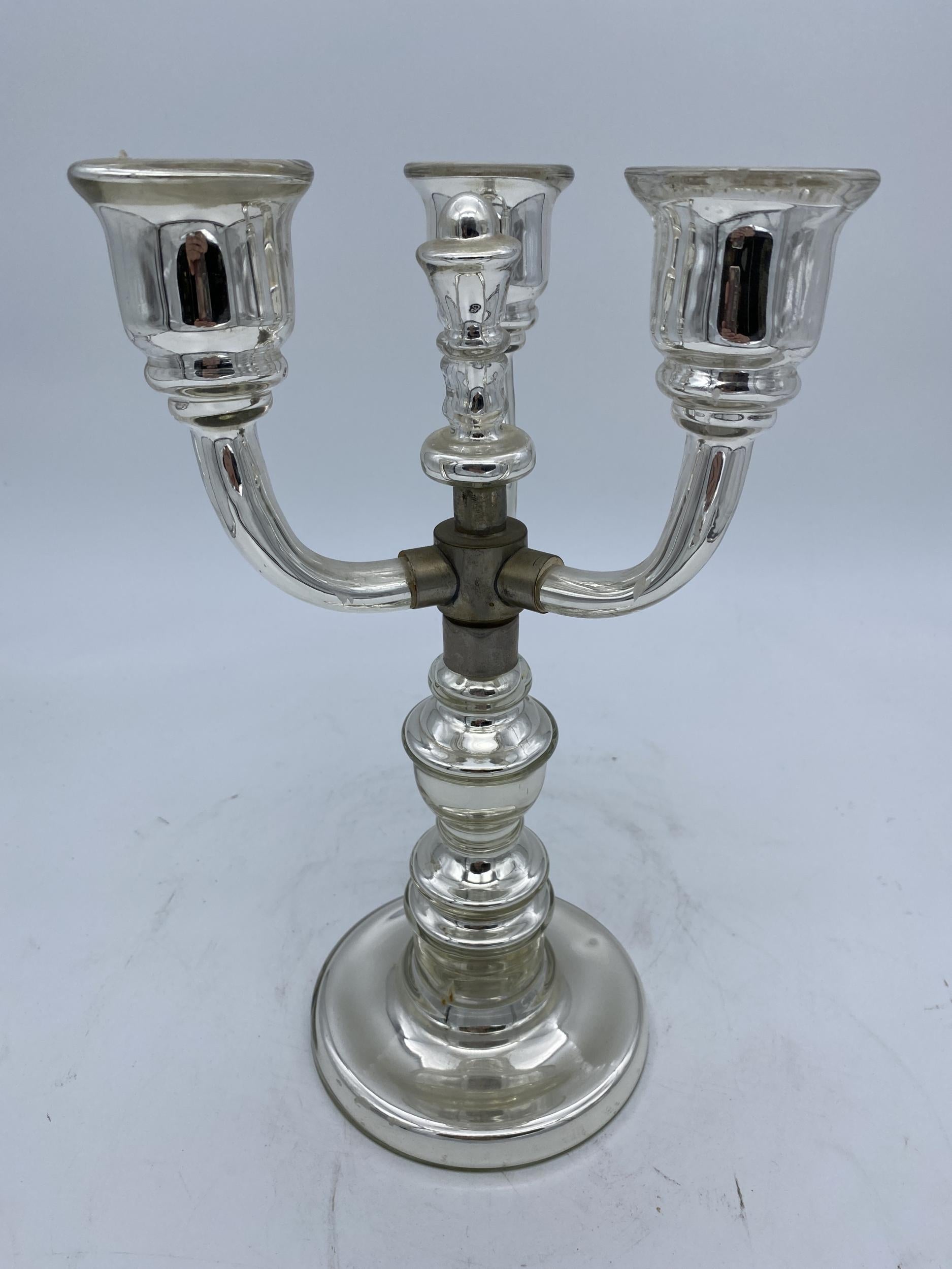 Original 1930s mercury glass candle ctick holder featuring 3 arms connected by metal connecting piece. 

Mercury glass is glass that was blown double walled, then silvered between the layers with mercury and sealed.