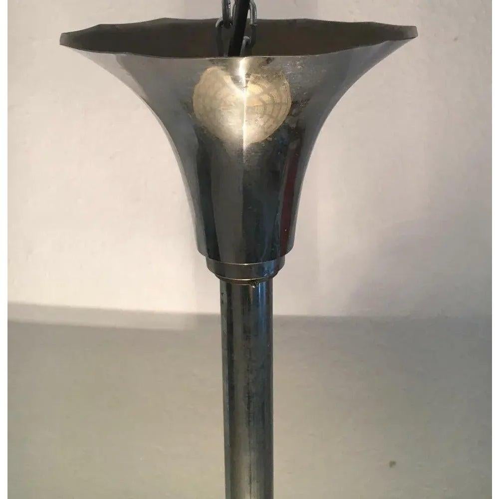 Plafoniera imponente e riservata in vetro e metallo.

L'ombrello è progettato come una ciotola piatta in vetro spesso. Il vetro è dotato di un semplice ornamento sul lato inferiore. L'effetto luminoso è supportato dal colore giallo-verde del vetro.