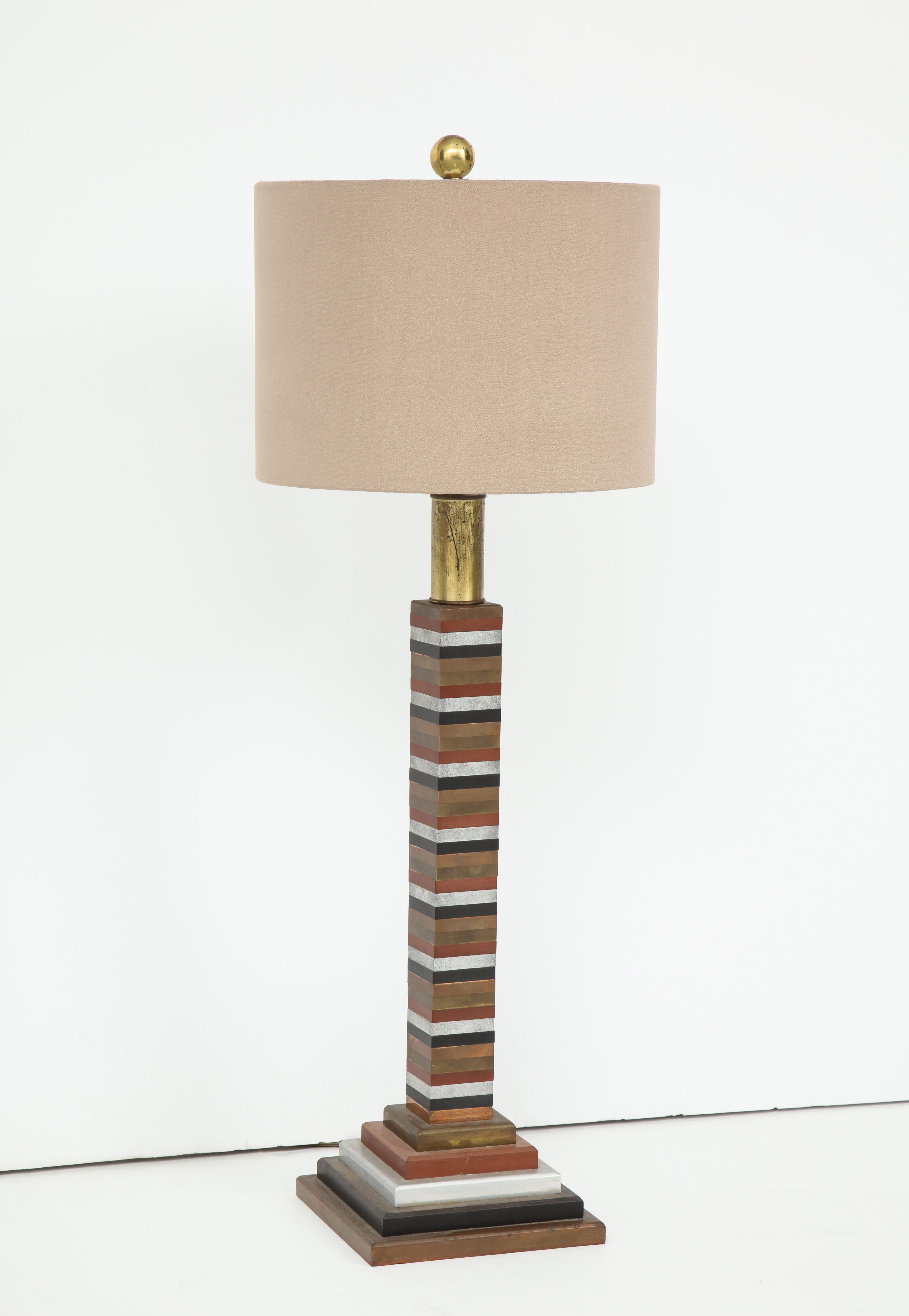 Great skyscraper style table lamp made from segmented mixed metals. In the manner of Donald Deskey.