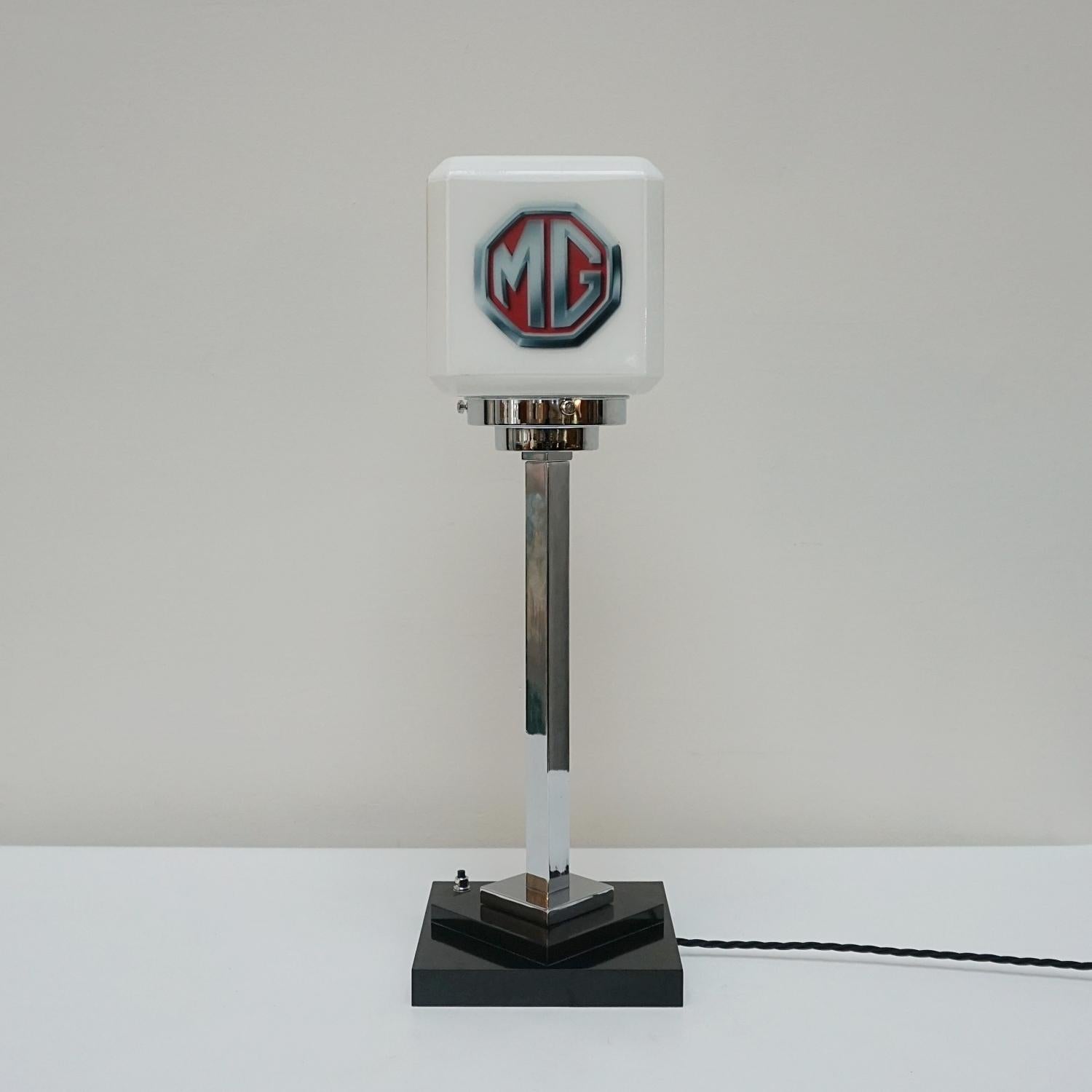 An original tall Art Deco table lamp. Encompassing the emblem of British Car manufactures 'MG' (founded 1920). Raised on a bakelite stepped base with chromed stem. 

Dimensions: H 55cm W 17.5cm D 17.5cm

Origin: English

Item Number: J310

All of