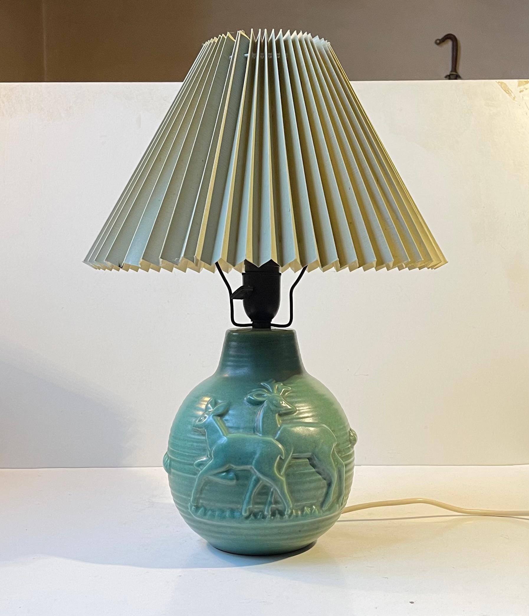 Art Deco styled Michael Andersen & Son ceramic table lamp with fluted green shade. Axel Salto inspired relief deer theme and celadon green. It features its original bakelite sockets with on/off switch and period bronze shade holder. This design