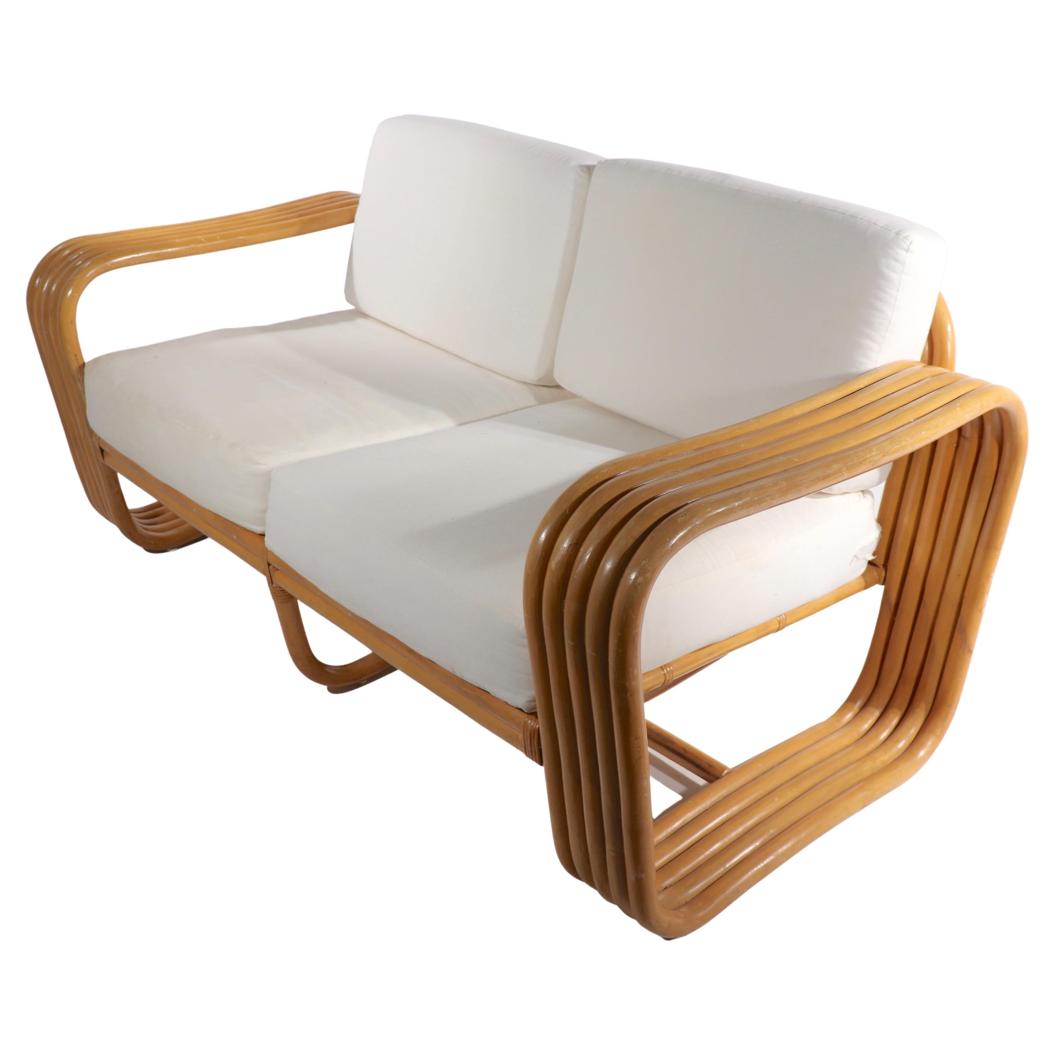 Stylish and chic Art Deco mid century bamboo loveseat, sofa. Nice wide ( 7 in. ) 5 band thick arms, good clean condition, cushions currently in muslin, ready for your fabric. Design reminiscent of Frankl, unsigned. 
Measures: Total H 30 x arm H