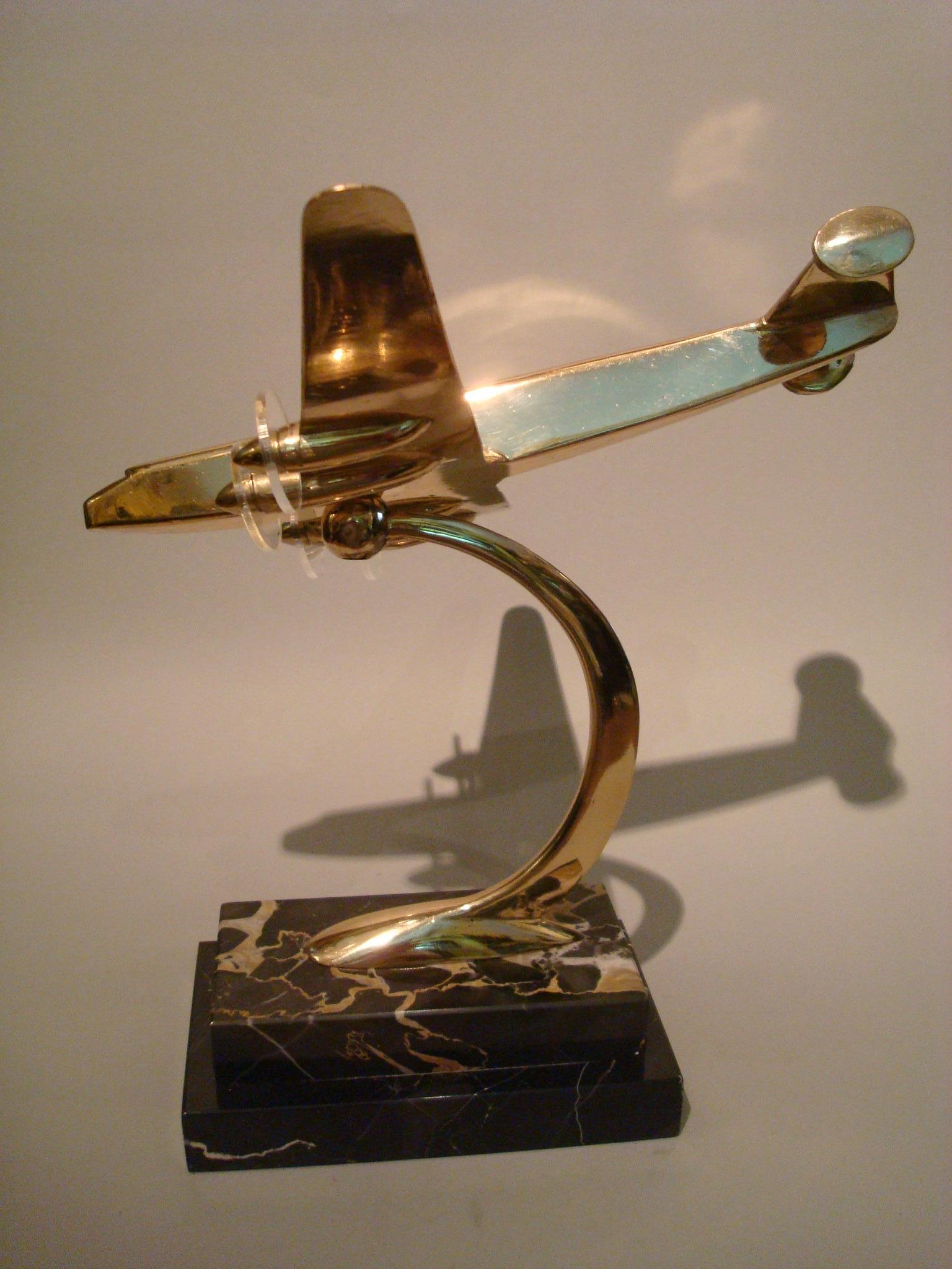 Art Deco / midcentury desk model Airplane with marble base, 1930s.
Airplane is mounted over a black and gold Italian base (Portoro).
It has acrylic propellers.

Item has been perfectly restored. Mint conditions.
 