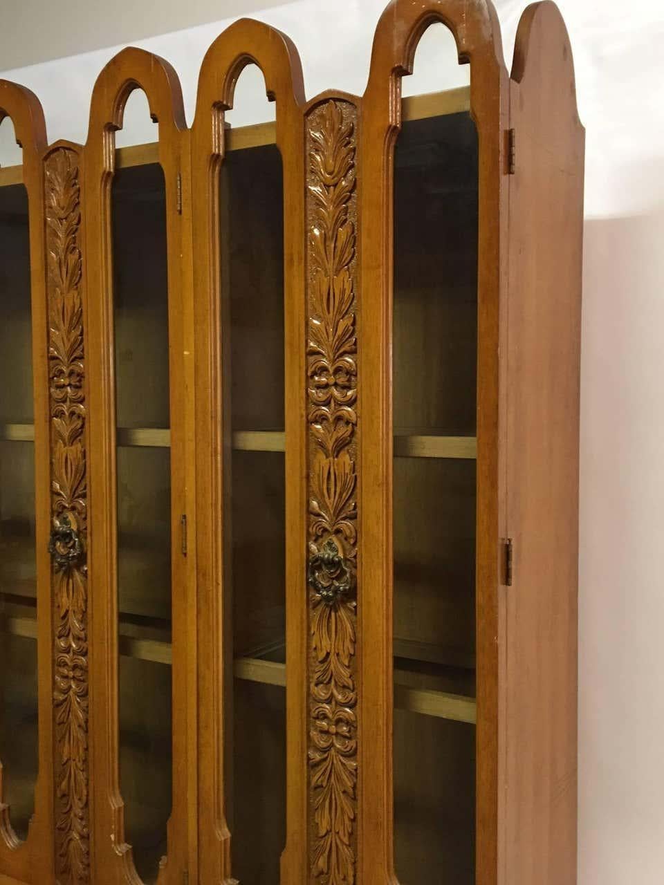 Monumental mid-century china cabinet. Beautiful ornately carved detail surrounds the front glass doors. Top hutch features interior lights and glass display shelves. Lower credenza or sideboard features interior drawers and shelves. Good condition