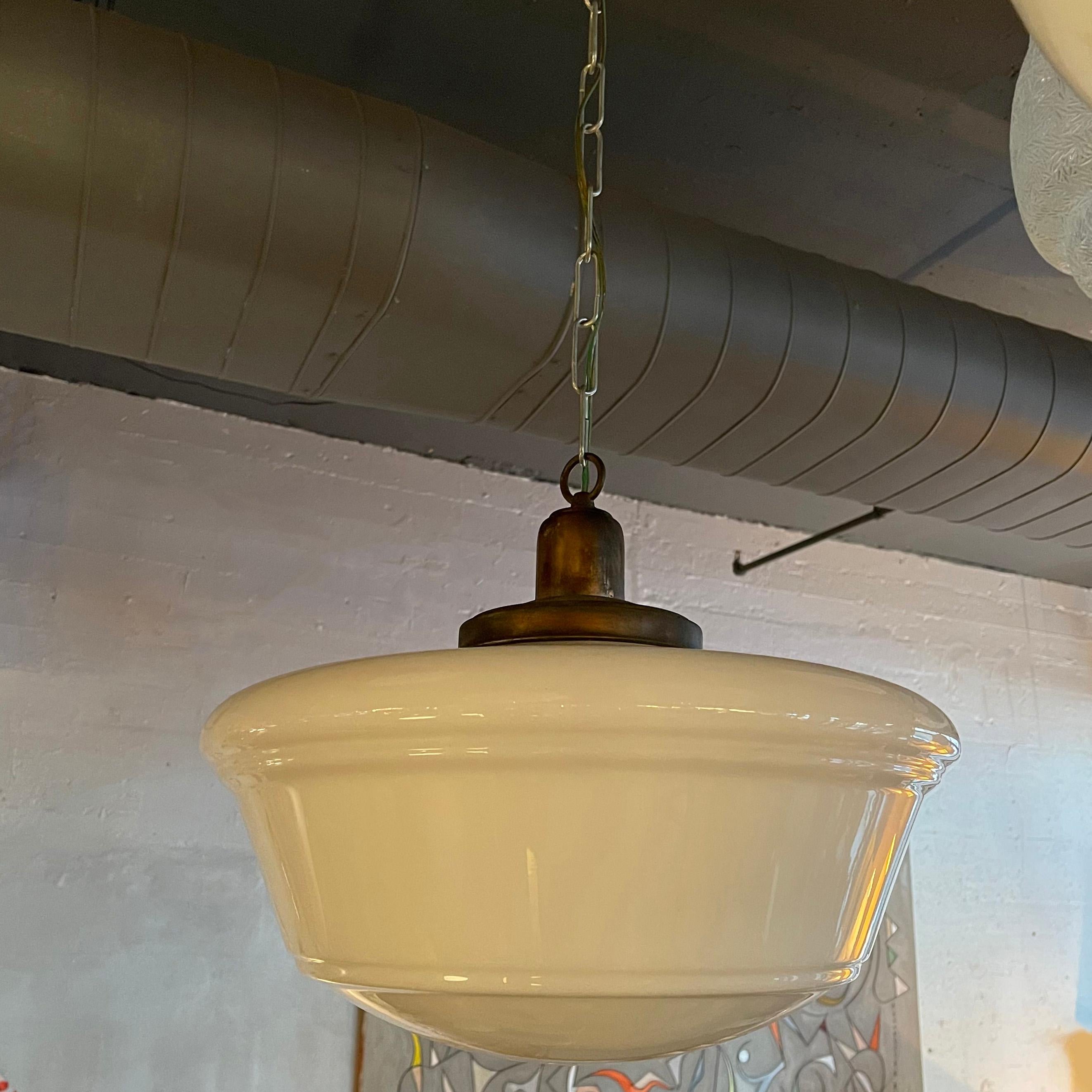 Art Deco pendant light with large 18 inch diameter, milk glass shade, brass fitter, chain and canopy is newly wired to accept up to 200 watt bulb and hangs at an overall height of 68 inches.
