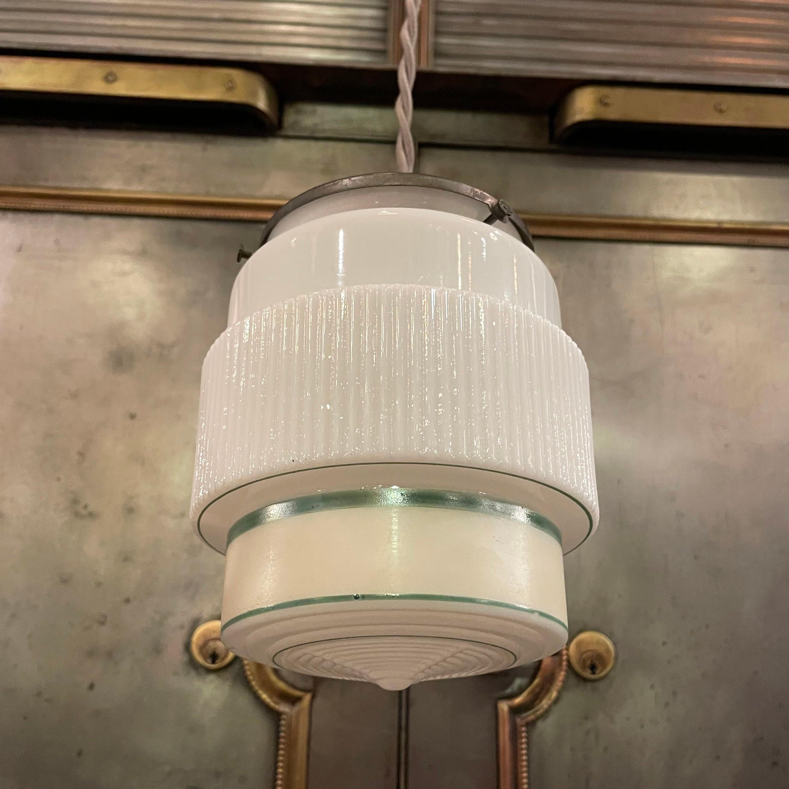 Art Deco pendant light with a layer cake, green stripe, milk glass shade and gunmetal hardware is newly wired with 48 inches of gray braided cloth cord.