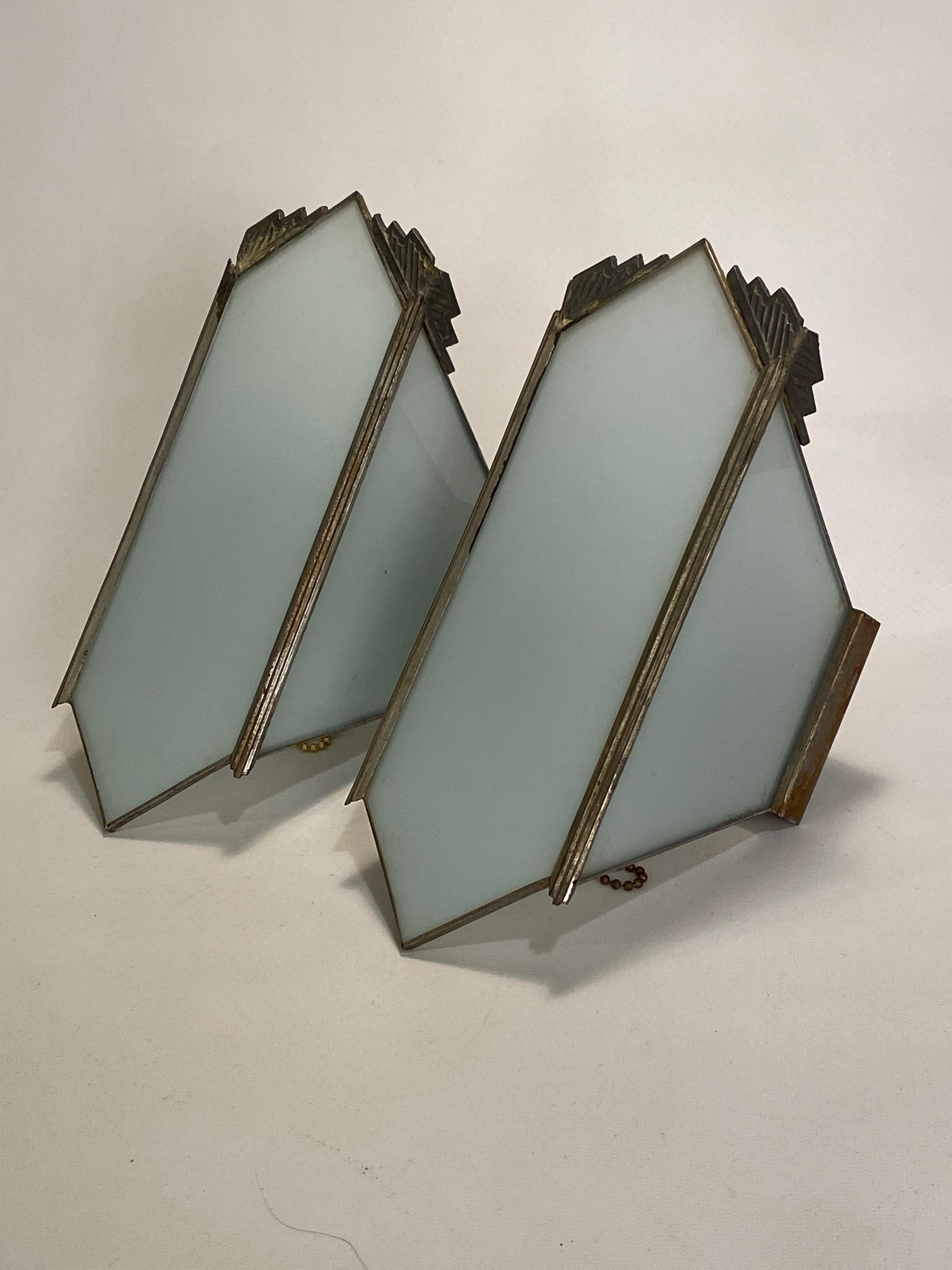 A fine pair of Art Deco three panel milk glass sconces. Just a small amount stepped metal detailing in the upper corners of the sconces and the vertical reeded exterior panel support. One front hexagonal pane of glass flanked by two trapezoidal