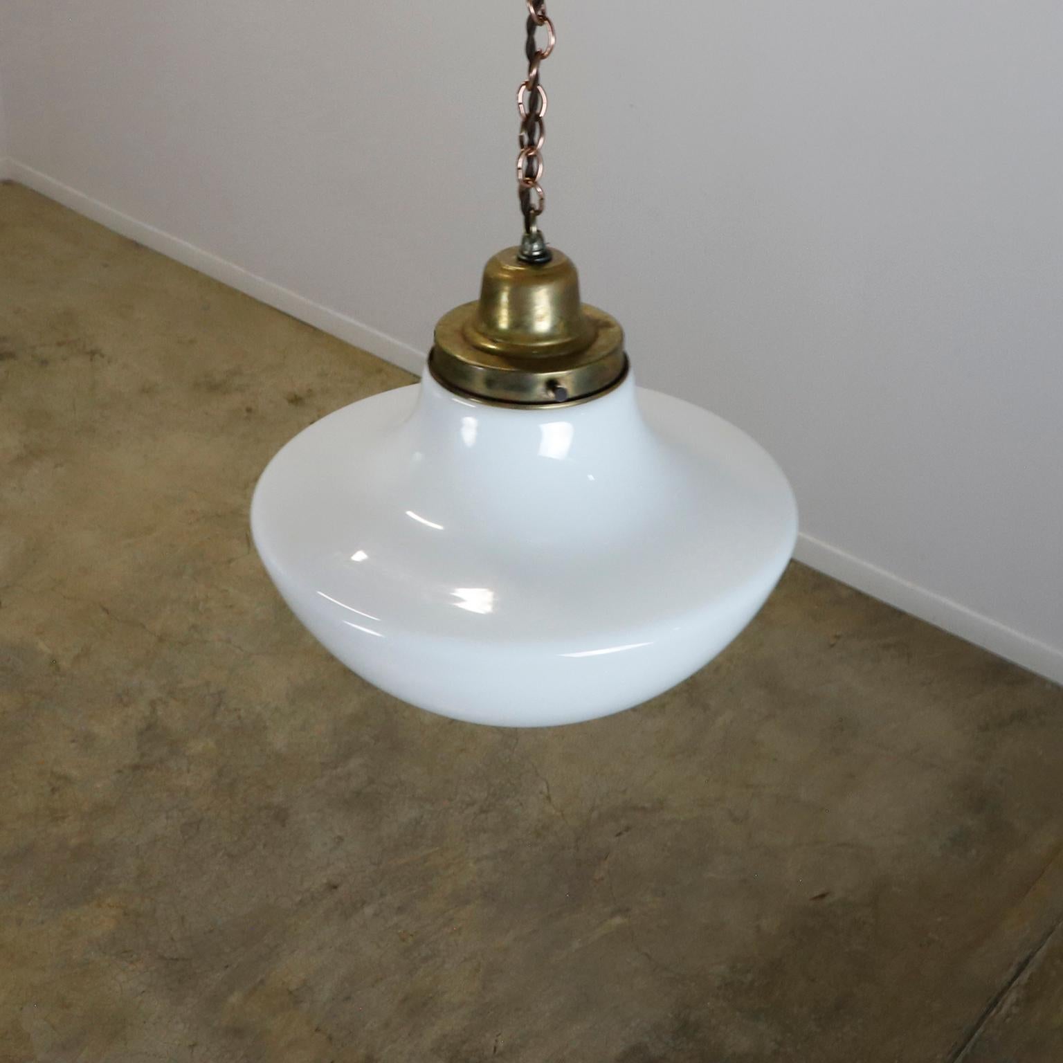Circa 1930. Nous vous proposons cette suspension Art Déco, réalisée en verre au lait. travaillant à la perfection. La lampe a un éclat sur le dessus. Cet éclat est imperceptible lorsqu'il est recouvert de la couverture en bronze. Voir image 5