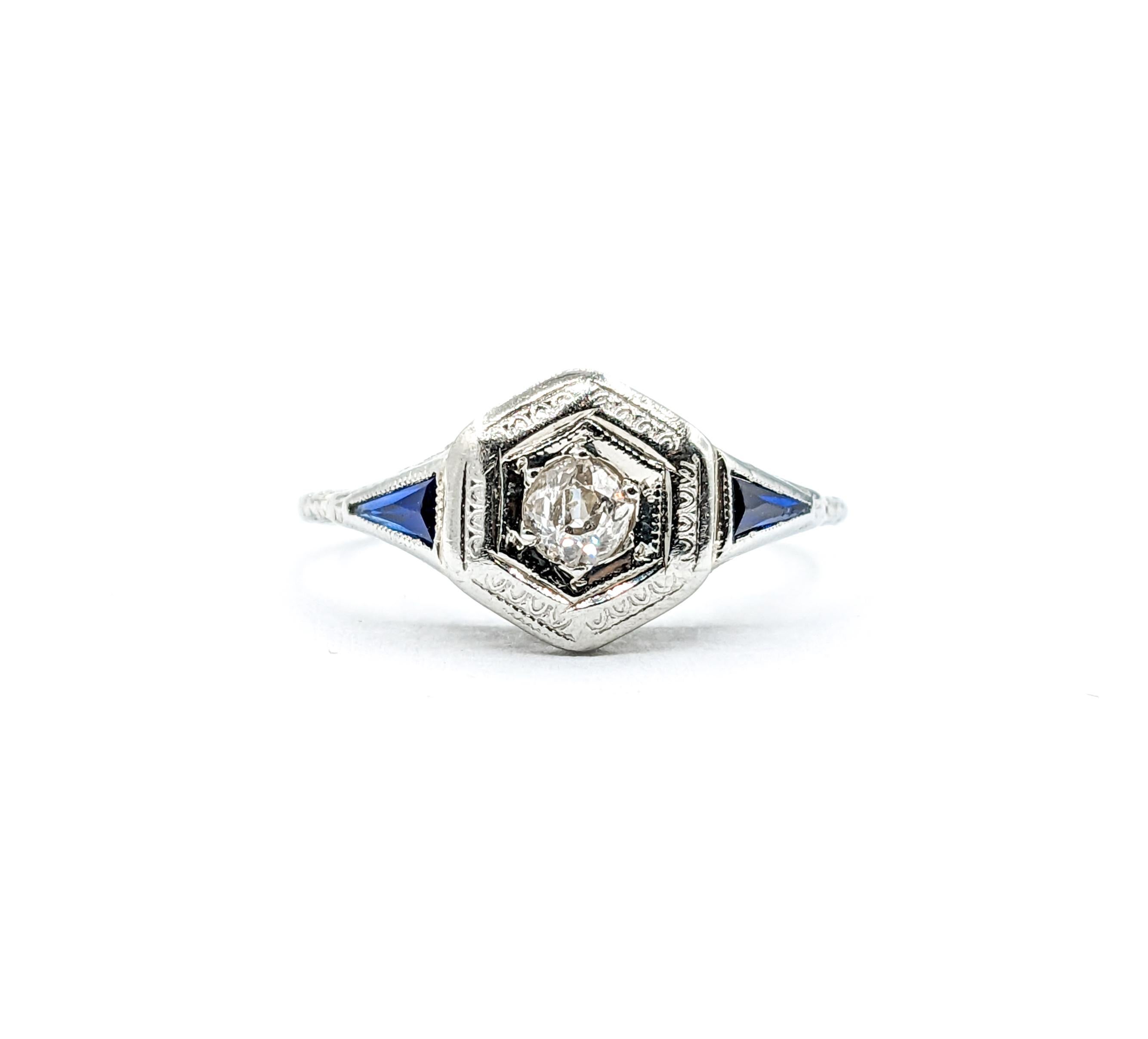 Art Deco Mine Cut Diamond & Sapphire Ring in 18k White Gold

Experience the allure of the past with this exquisite Art Deco ring, skillfully fashioned from 18kt white gold. At its heart lies a .15 carat mine cut diamond, bursting with brilliance and