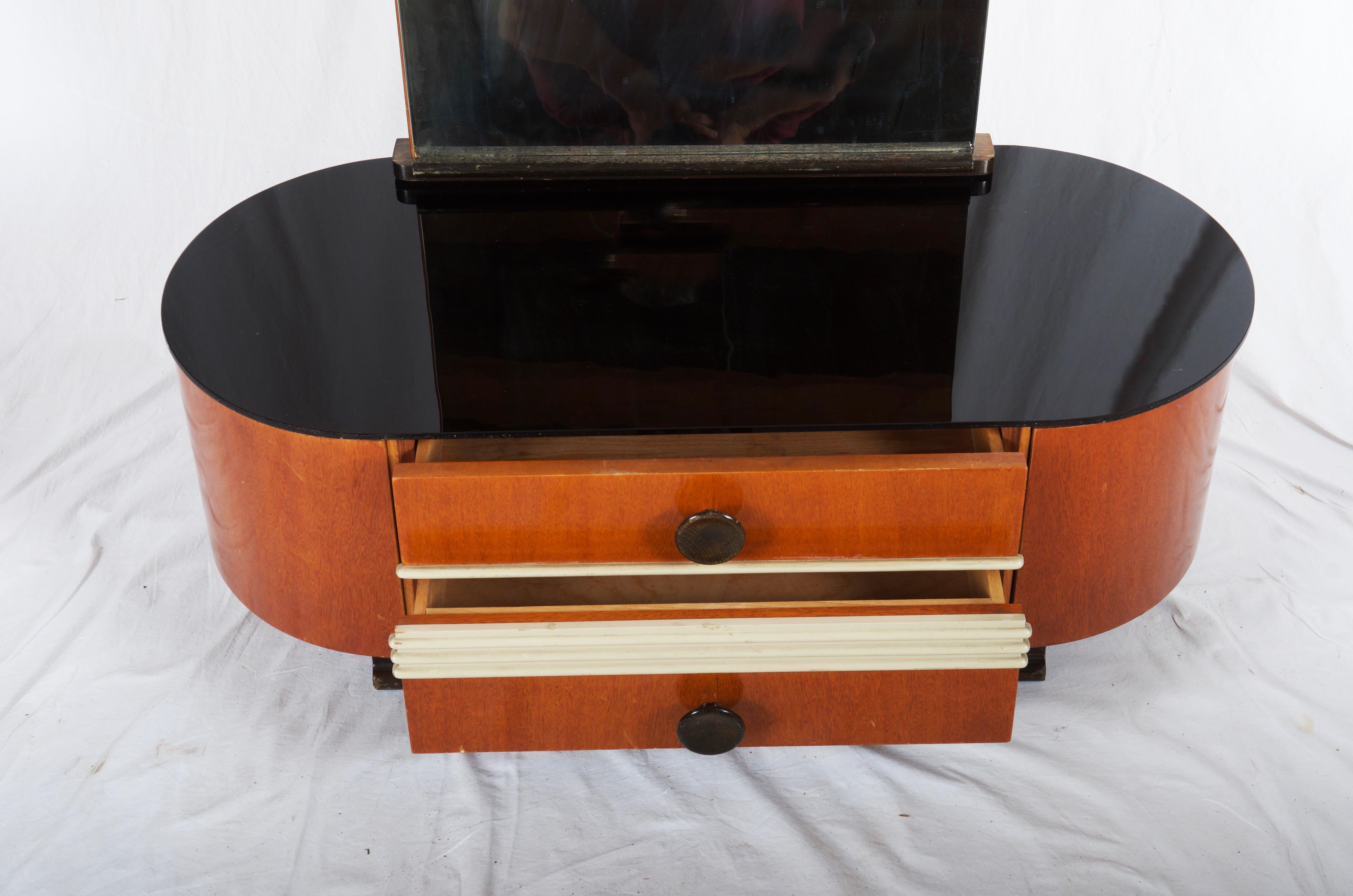 Wood construction with two drawers, black glass top, and lager mirror. Designed by Jindrich Halabala in the 1930s for UP-Závody.
Original unrestored condition.
