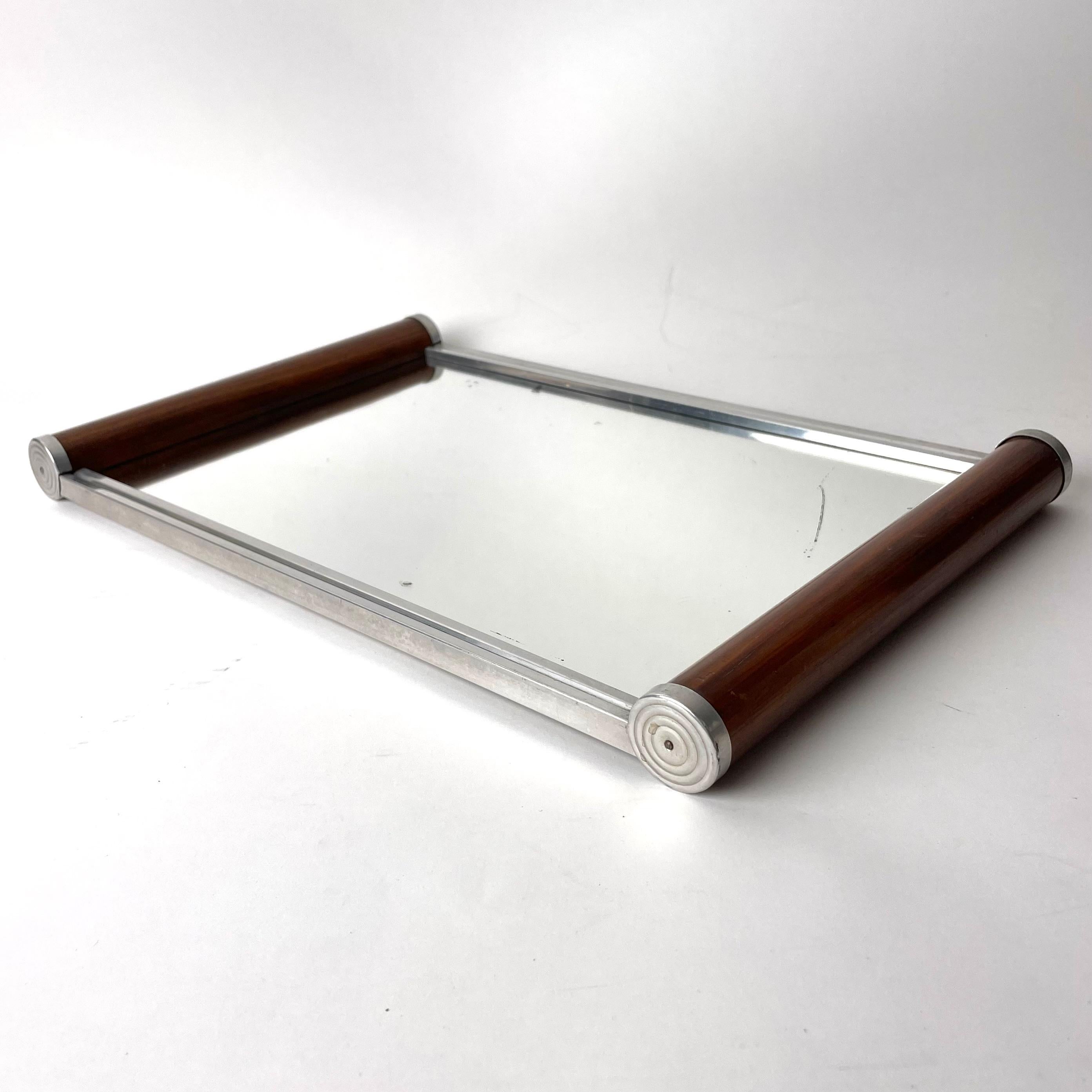Art Deco Walnut and White Metal Mirror Tray, Europe from the 1920s or possibly the 1930s.

A refined Art Deco mirror tray. Features typical Art Deco, slight circular geometrical patterning in metalwork at edges of round handles. Melds materials