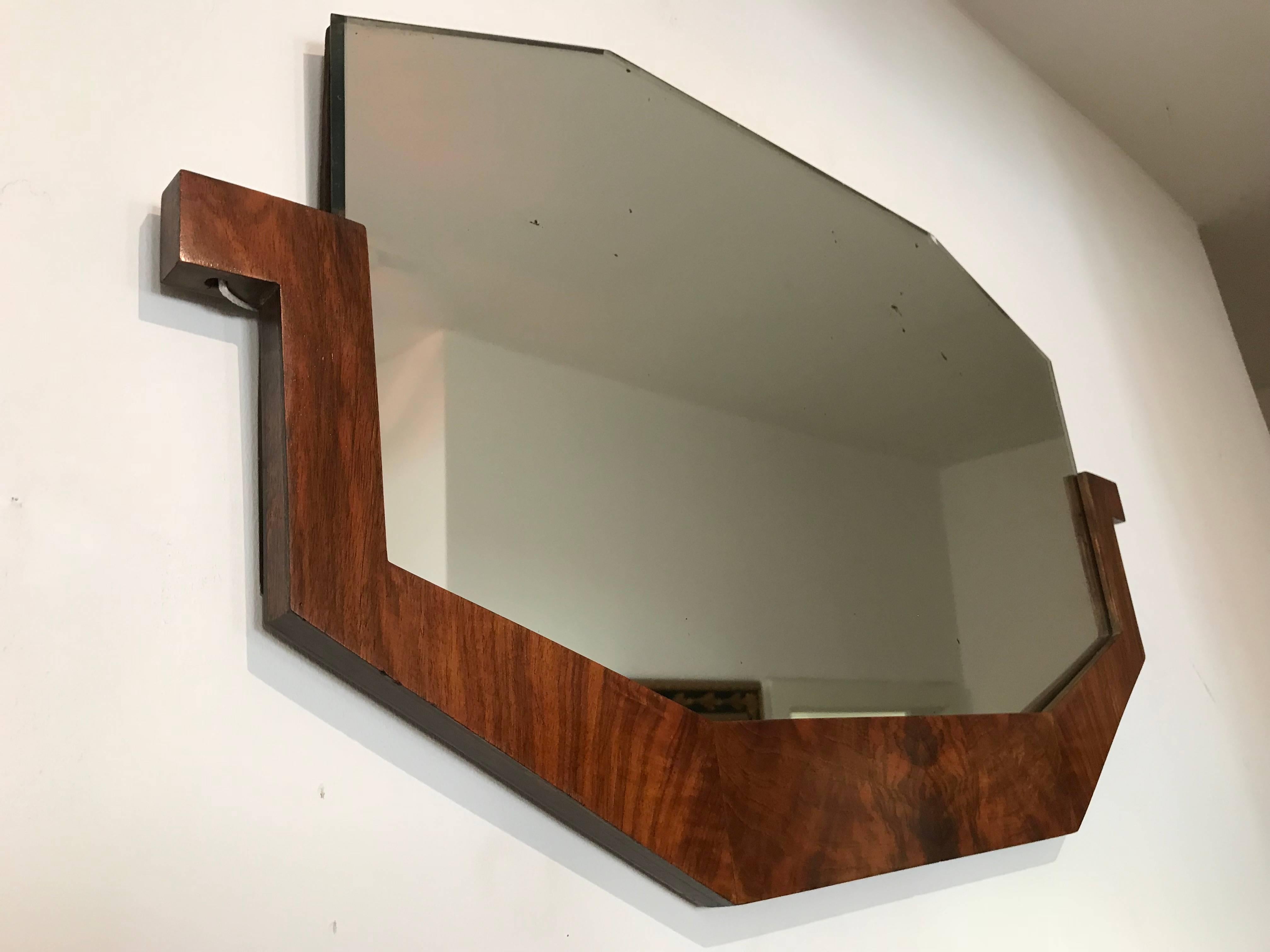 Wonderful original Art Deco Mirror from France, circa 1930. 
The frame is solid and veneered walnut with a nice grain and hand-polished with shellac. The mirror glass is still the original.