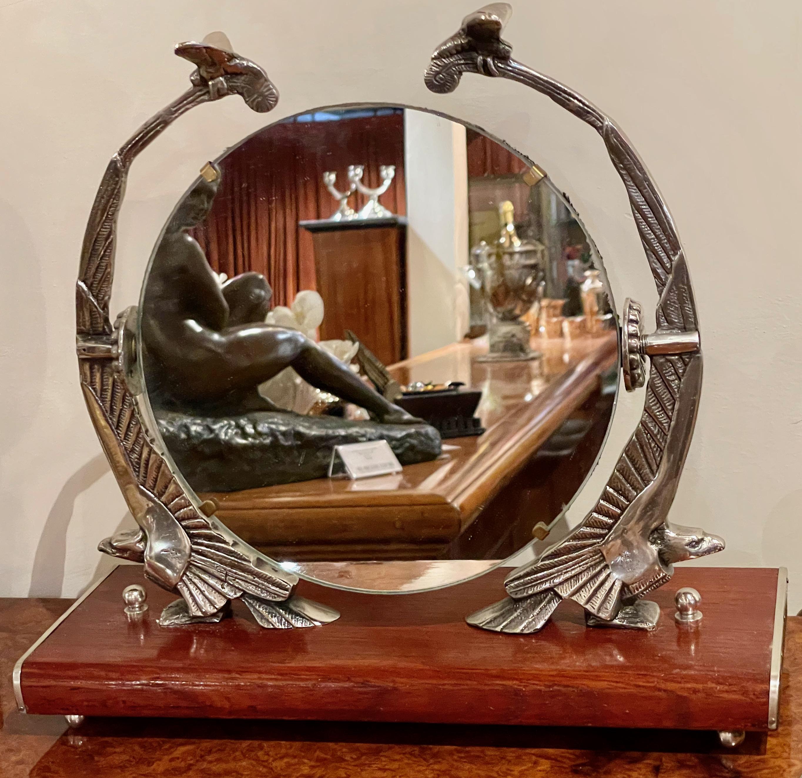 Art Deco mirror with Eagle sculpture supports on a wooden base. Unique cast metal sculpture gives this decorative vanity style mirror not only limitless possibilities for placement in your home but reflects much more than this circular mirror. The
