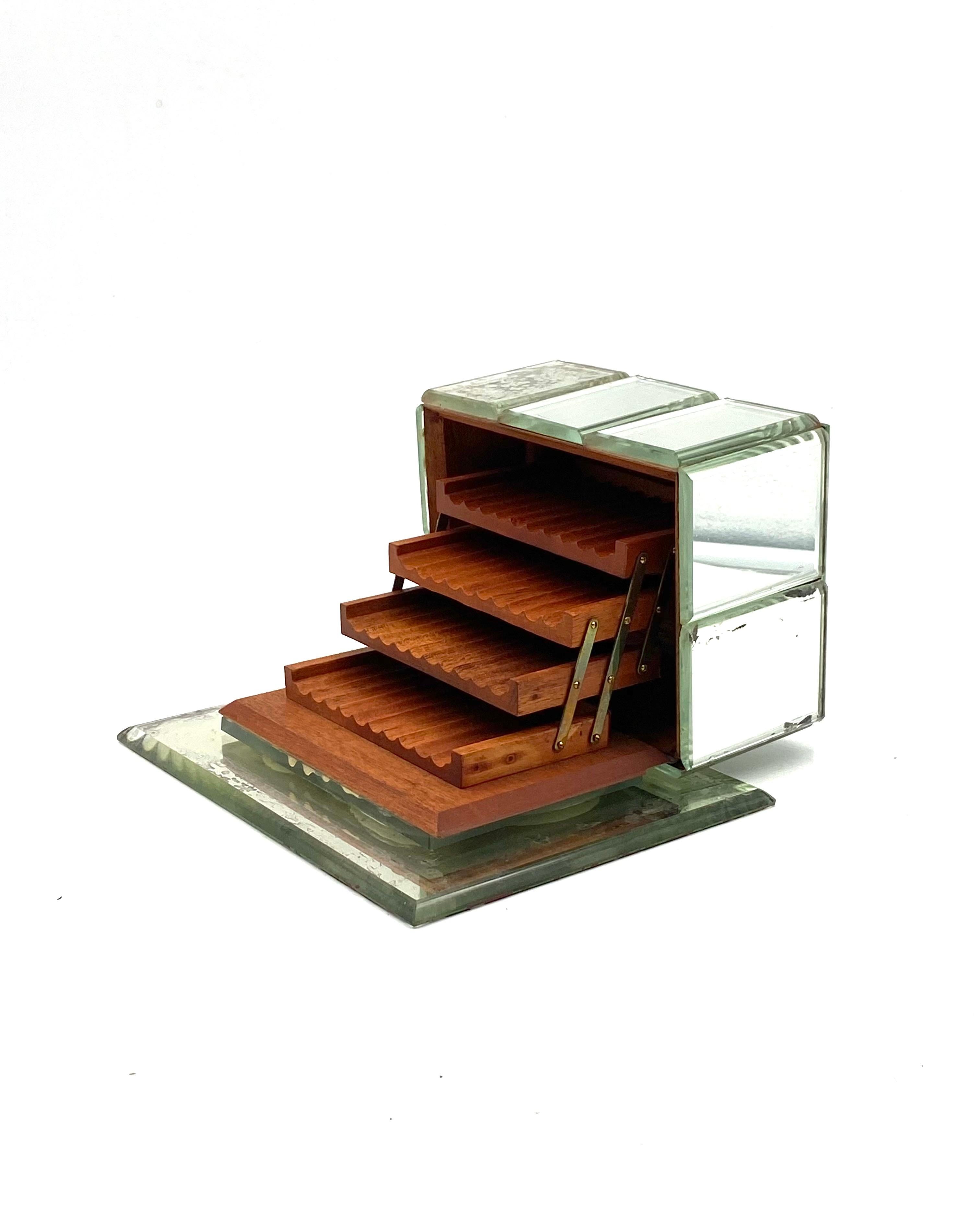 Art Déco mirrored cigarette box 

Italy 1940

Etched and bevelled mirrored box sits on midnight mirrored glass base. Opens to 3 cedar wood shelves.

H 11 cm - 21 x 17 cm

Conditions: good consistent with age and use, Mirror ageing in multiple places