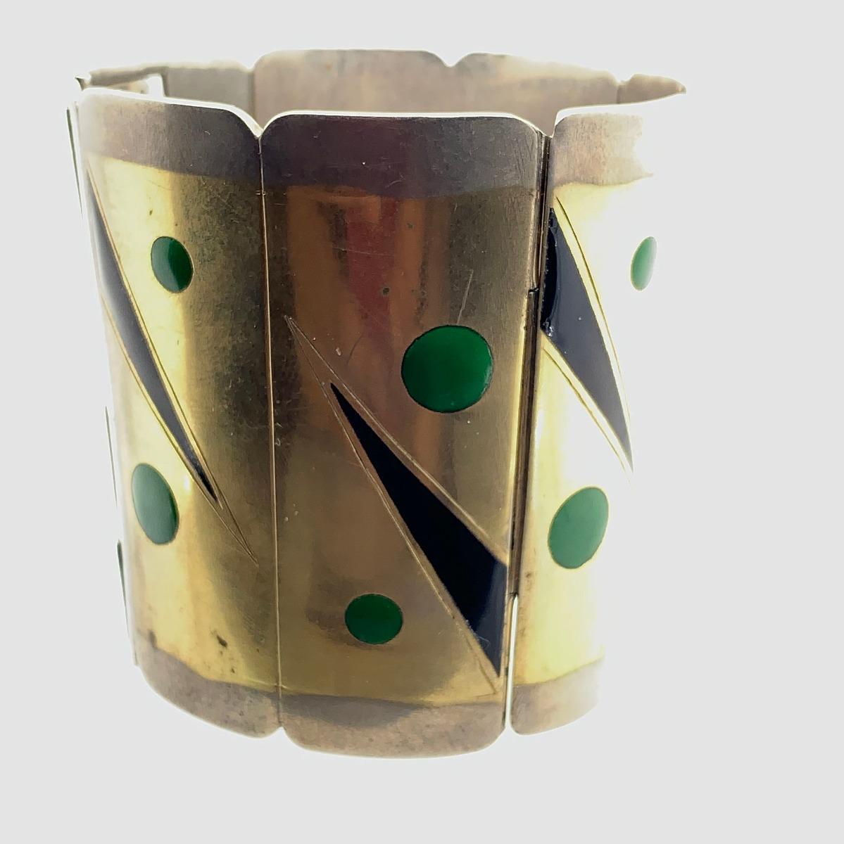 Material: Puño bisagra cónico con esmalte negro y verde
Marca del fabricante: GC
Estado: Bueno
Año de fabricación: 1930
Gema: N/A
Peso total del artículo: 161 gramos
Longitud: 4,14 pulgadas
Circunferencia interior: 7 pulgadas
Flecos articulados
551