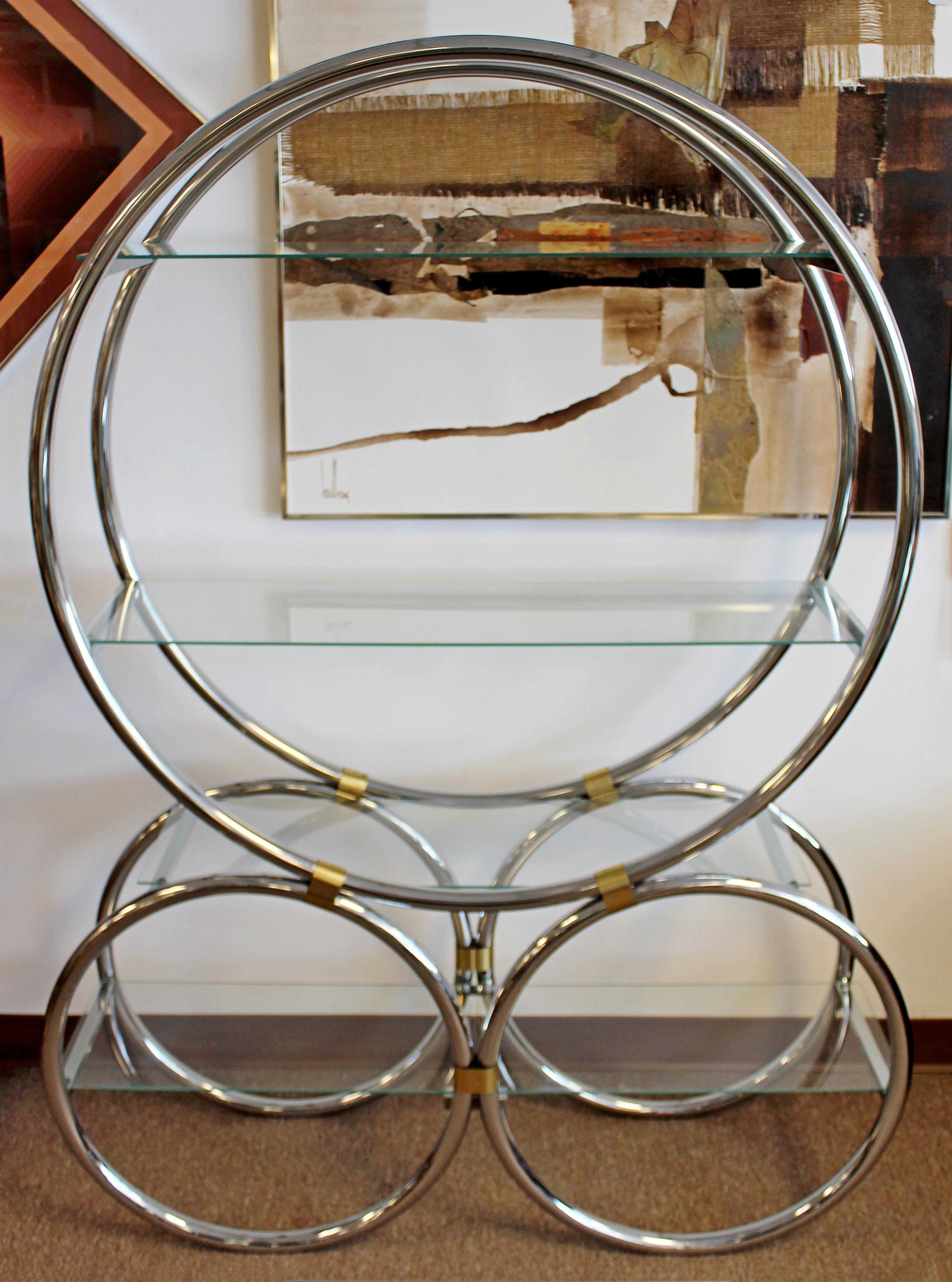 For your consideration is a sensational, chrome and brass shelving unit étagère, with four glass shelves, circa 1940s. In excellent vintage condition. The dimensions are 48