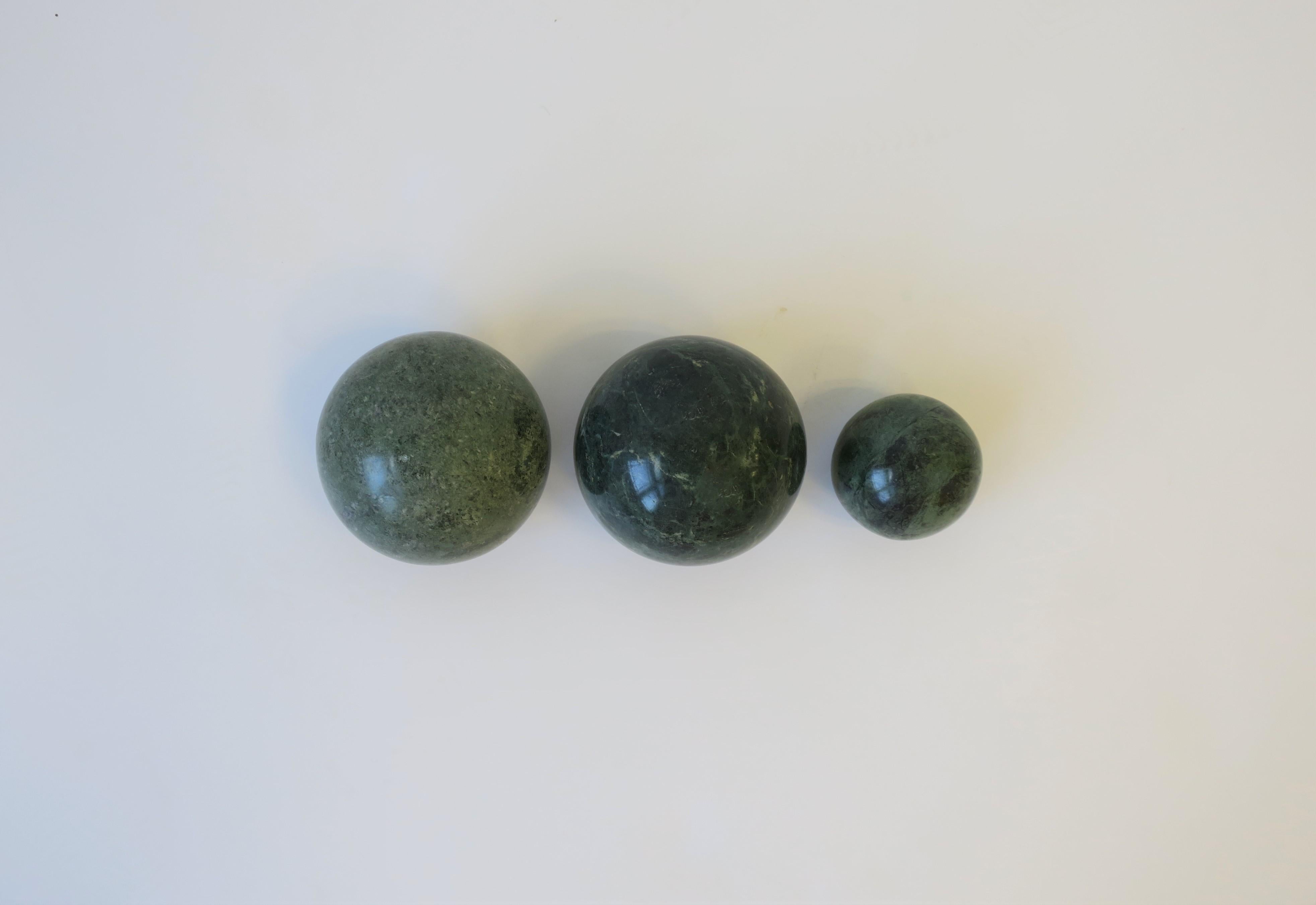 A great set of three (3) 1970s Art Deco Modern dark green marble decorative sphere's. The two larger sphere's have a 'flat' bottom. Measurements include: two measure 3.25