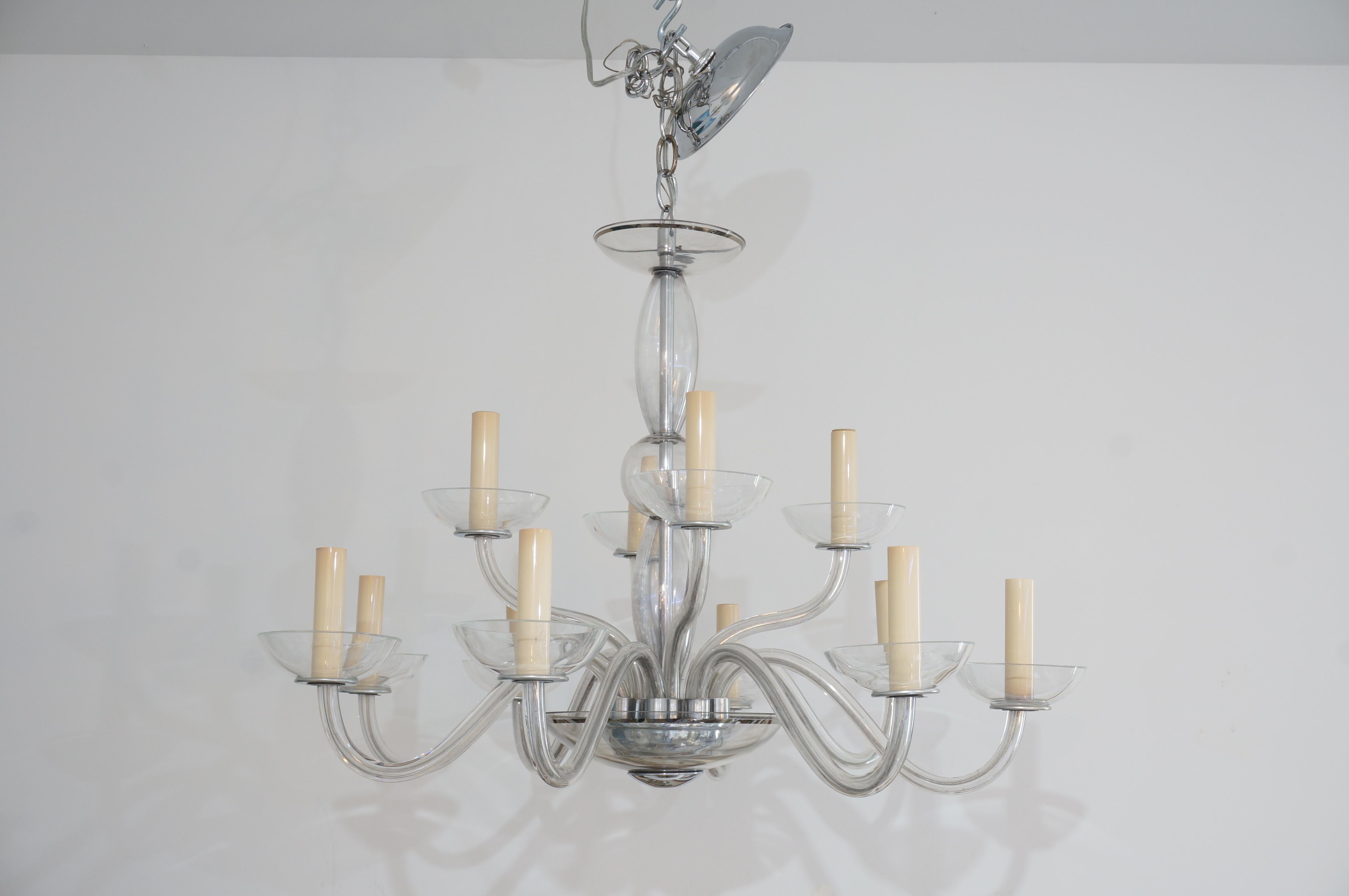 This stylish and chic moderne style chandelier dates to the 1930s-1940s and is fabricated in Czech glass with a slight grey tinge to the glass, chrome hardware and sterling silver overlay. 

Note: Requires 12 candleabra based light bulbs.

Note: