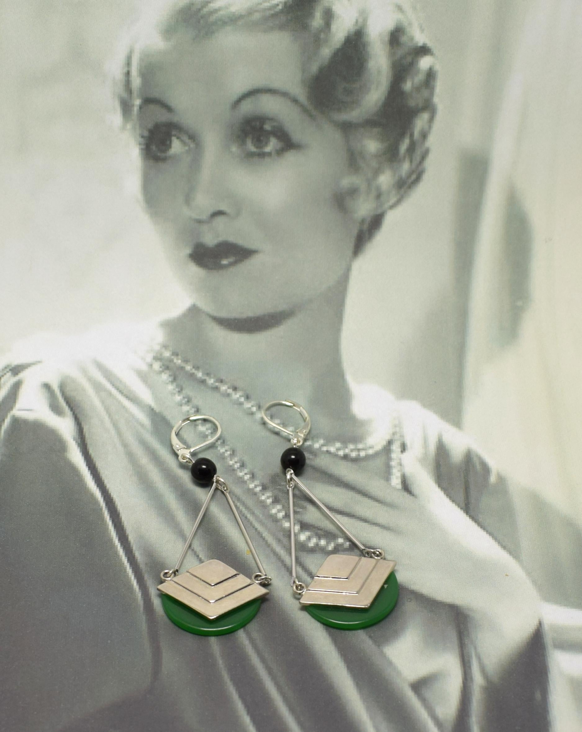 Beautiful piece of jewellery dating to the 1930's are these modernist pair of drop earrings. Features stepped geometric chevron shapes in mirror chrome with jet Black & green phenolic Bakelite accents. New Silver plated lever backed wires have been