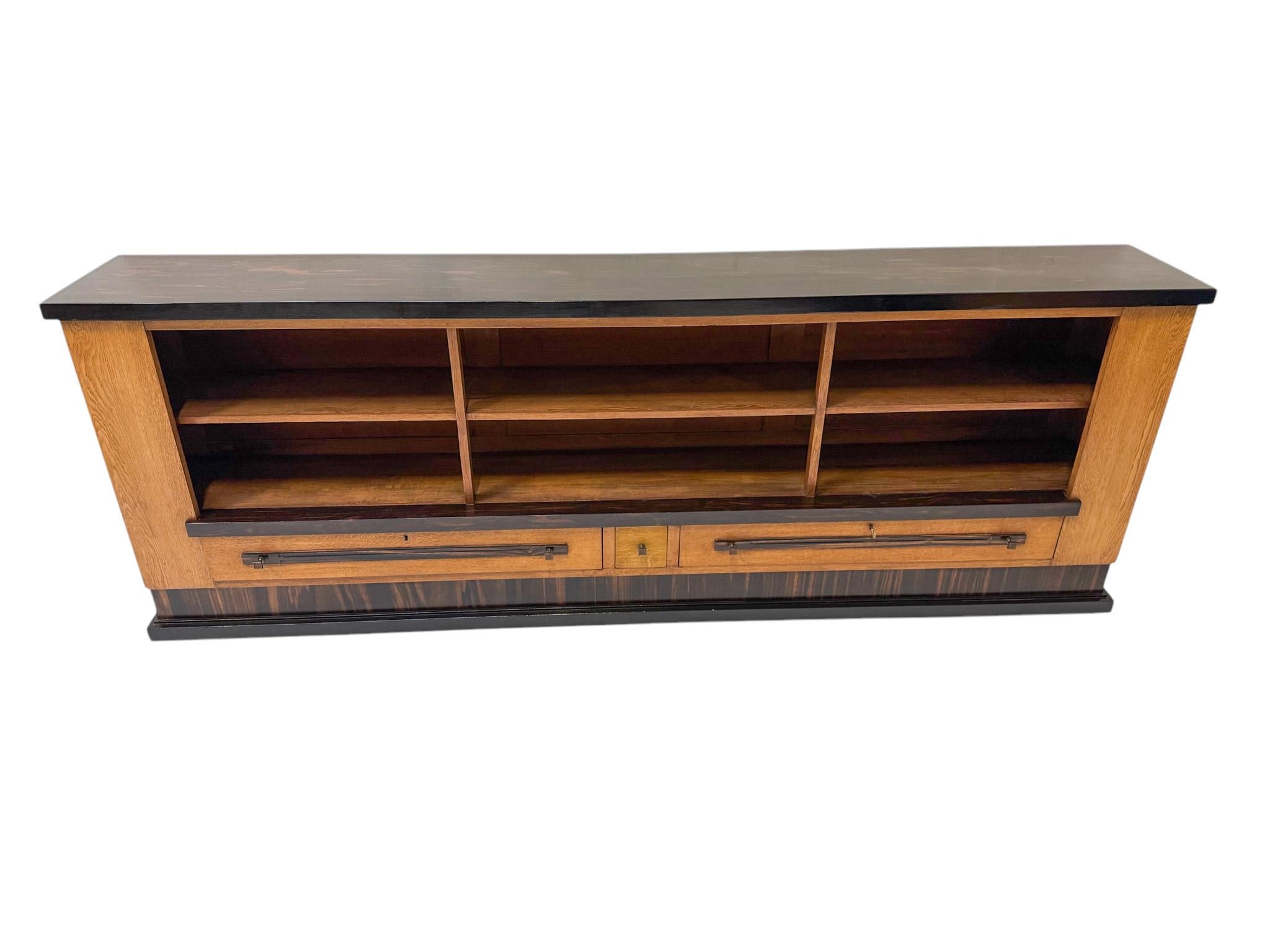 Magnifica e rara libreria o credenza modernista Art Déco.
Design di Hendrik Wouda per H. Pander & Zonen Den Haag.
Un sorprendente design olandese degli anni '1920.
Rara, per via della sua larghezza: 283,5 cm o 111,42 pollici!
Base in rovere