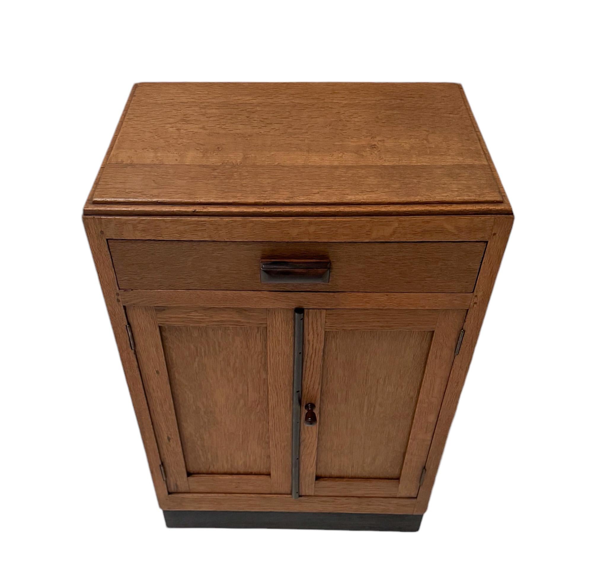 Impresionante y elegante armario modernista Art Déco con cajón.
Llamativo diseño holandés de los años 1920.
Base de roble macizo con tirador original de ébano de macasar macizo en el cajón.
La puerta derecha tiene un pomo original de ébano de