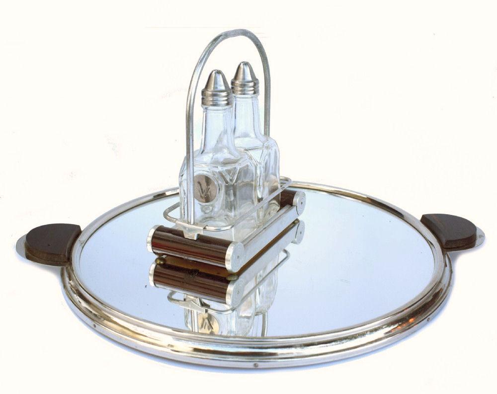 Very stylish Art Deco condiment set, dating to the 1930's and originating from France. Two bottles marked O and V to symbolise Oil and Vinegar are held in their own tray with a hooped carry handle. The base of the tray is mirrored and has two