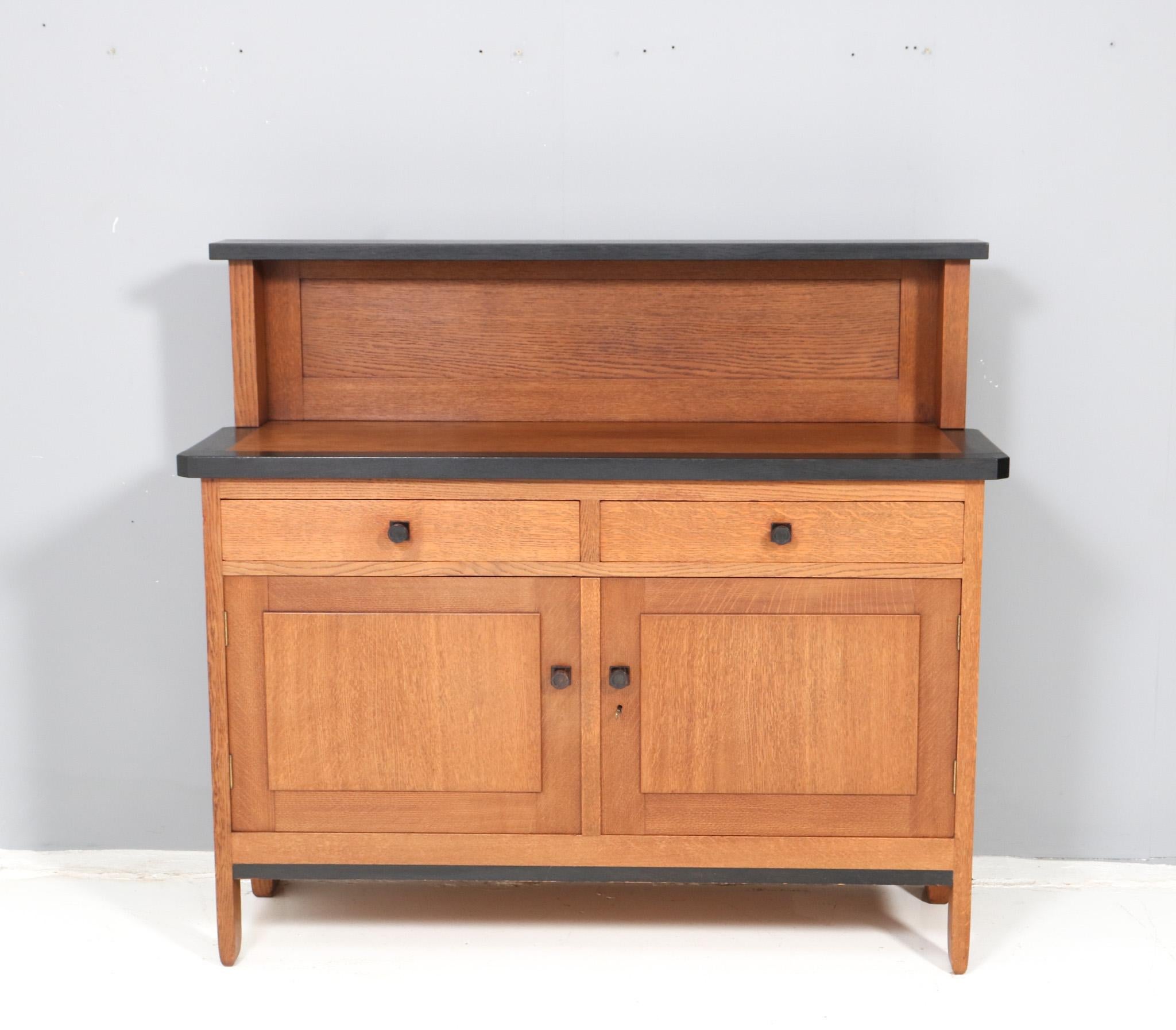Magnificent and rare Art Deco Modernist credenza or sideboard.
Design by H. Fels for L.O.V. Oosterbeek.
Striking Dutch design from the 1920s.
Solid oak base with original black lacquered elements.
Marked with original manufacturers tag.
In very good