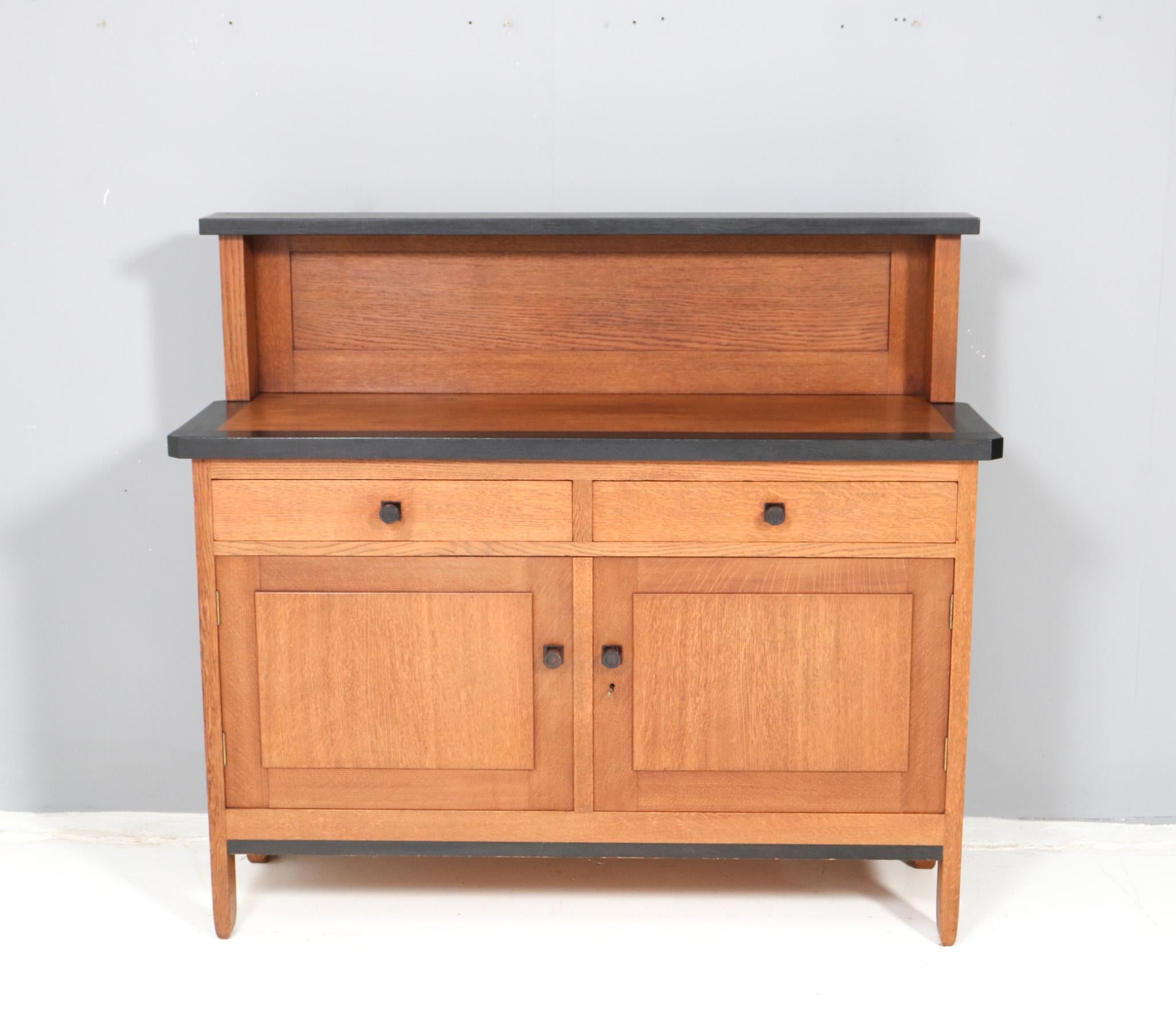 Magnificent and rare Art Deco Modernist credenza or sideboard.
Design by H. Fels for L.O.V. Oosterbeek.
Striking Dutch design from the 1920s.
Solid oak base with original black lacquered elements.
Marked with original manufacturers tag.
In very good