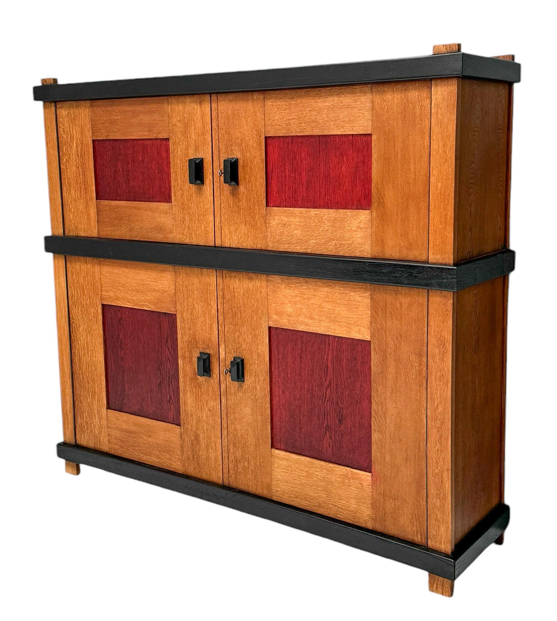 Magnificent and rare Art Deco Modernist cupboard or cabinet.
Design by Frits Spanjaard.
Striking Dutch design from the 1920s.
Solid oak with original red lacquered panels in the four doors.
Four original black lacquered handles on the four