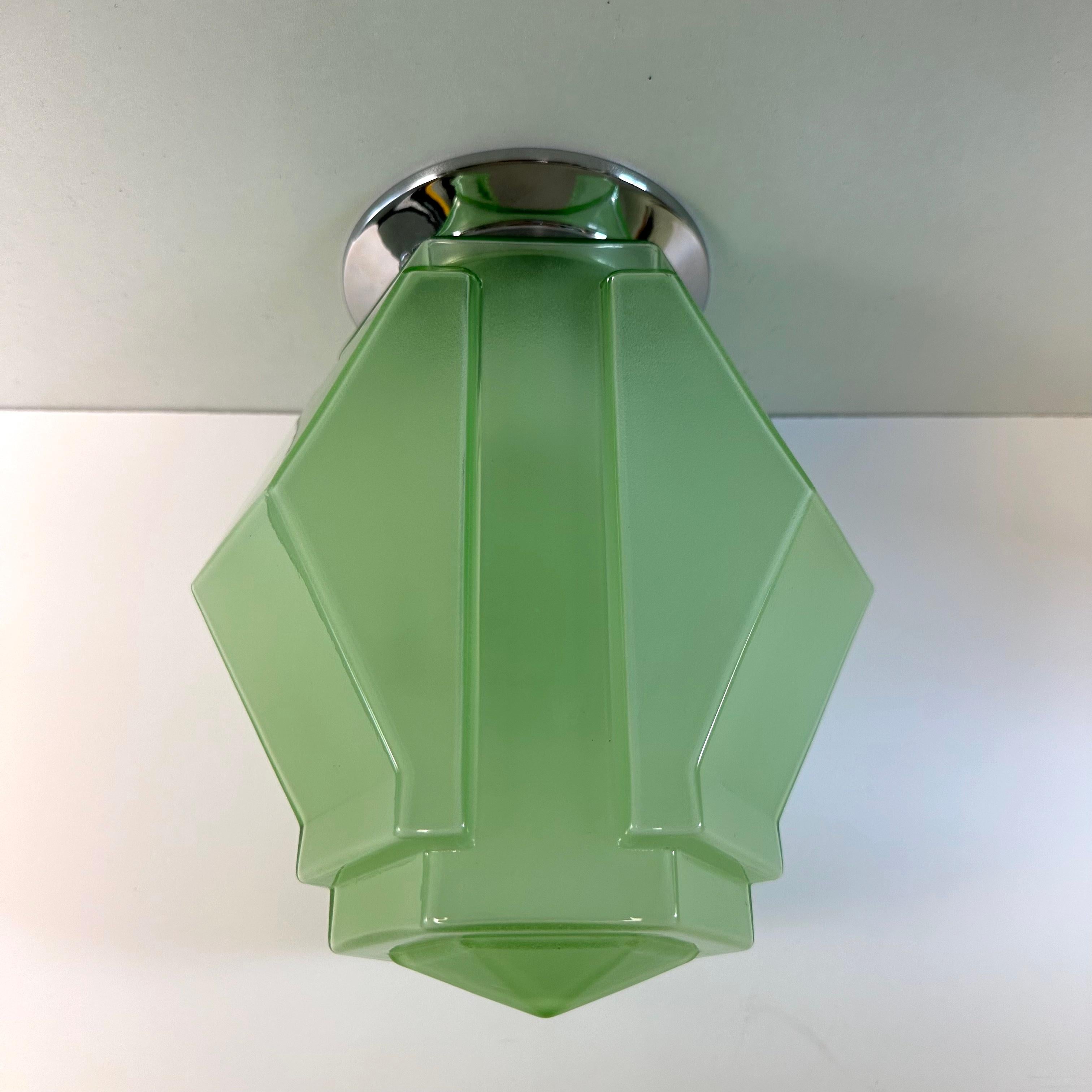 Gorgeous green Functionalist / Modernist Art Deco flush mount globe ceiling light. Pressed glass technique with a geometric layered, faceted and tiered skyscraper prism design. Green glass with a frosted finish applied to interior. Re-fitted with