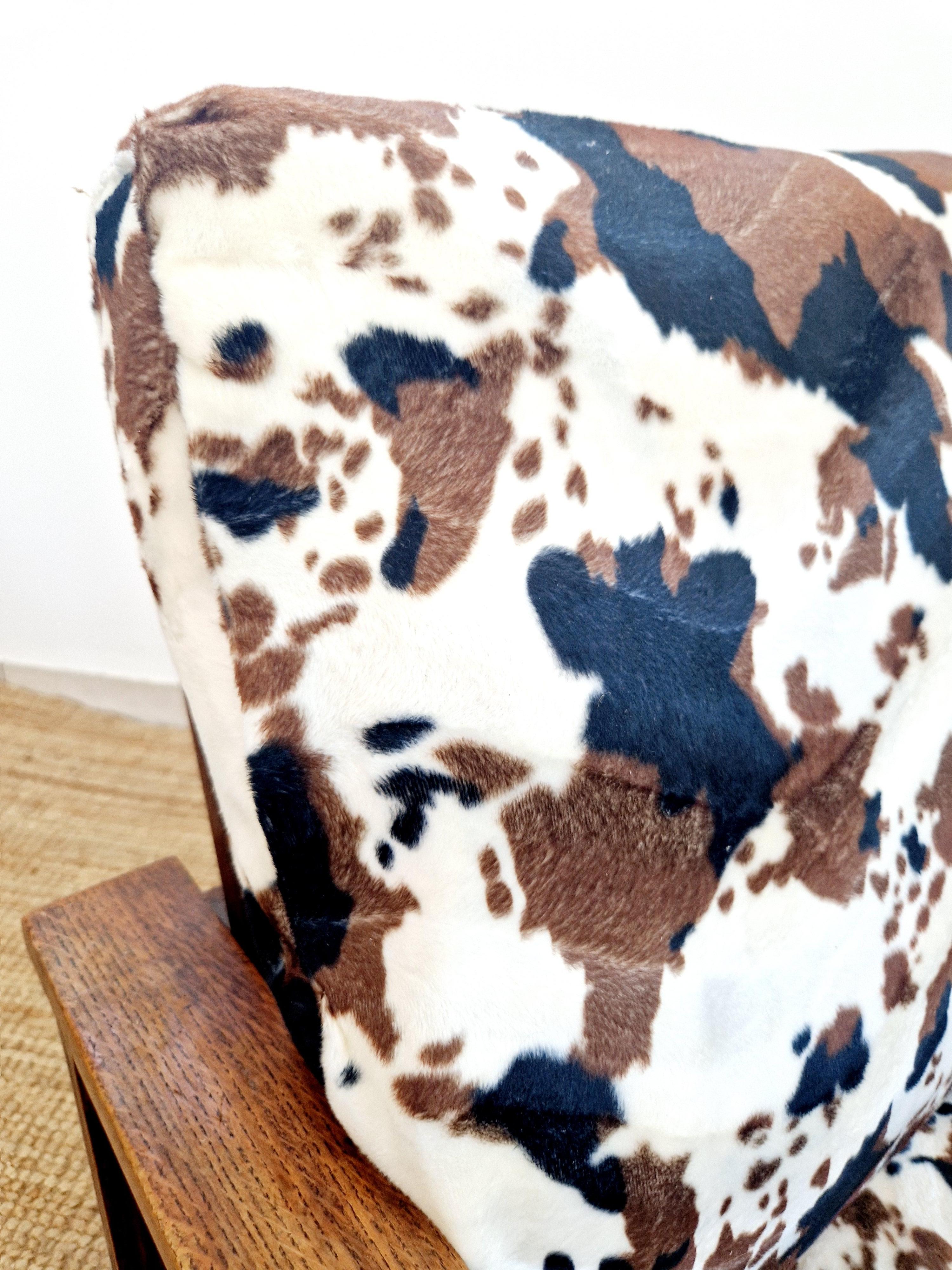Ce fauteuil inclinable de style Art déco et moderniste de Heal's est un meuble étonnant pour n'importe quel salon. Avec un revêtement à motif imprimé vache et un cadre en chêne, ce fauteuil dégage un charme unique et élégant. Fabriquée en bois de