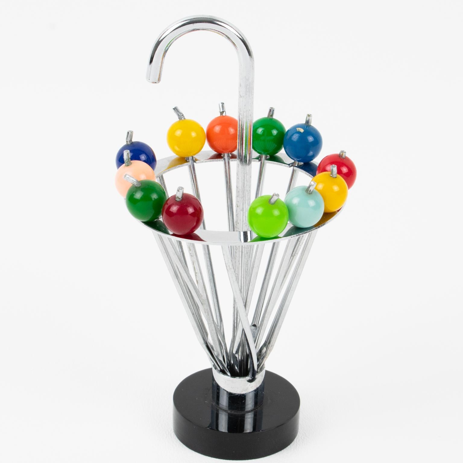 Este bonito utensilio de bar para servir picos de cóctel franceses tiene un soporte en forma de paraguas con doce picos y un remate de Lucite multicolor. Cada tenedor de cóctel puede extraerse del soporte metálico y utilizarse como pincho de cóctel