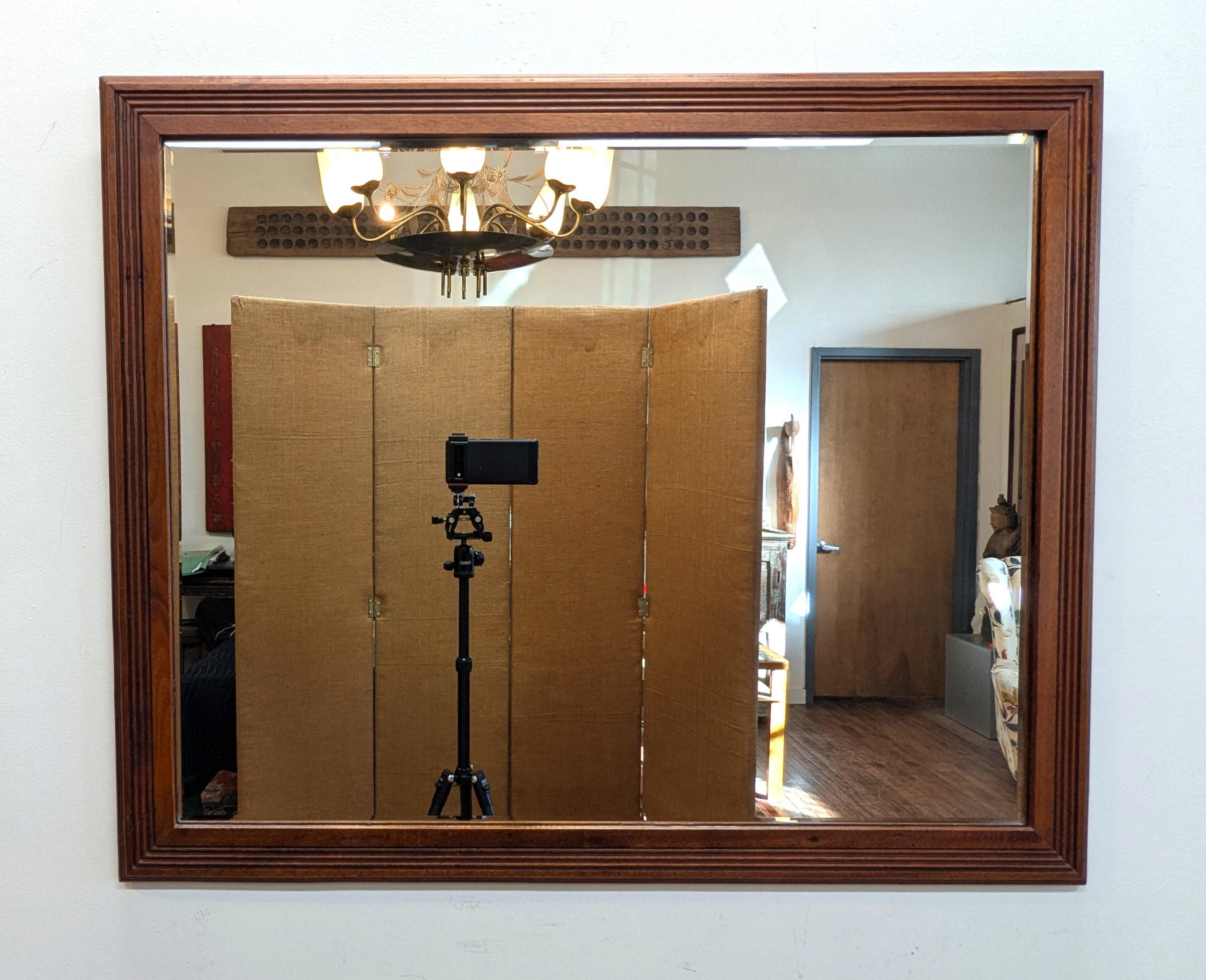 Art Deco Modernist Mirror having a carved linier detail of the period.  The four lines are arranged in a modernist style.  Solid Mahogany wood frame with beveled glass mirror.  In very good condition.  An old repair is slightly evident to one corner