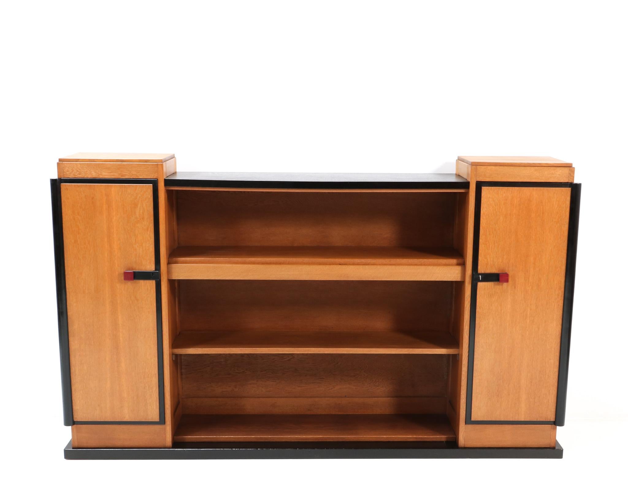 Magnificent and ultra rare Art Deco Modernist bookcase or credenza.
Design by Jan Brunott.
Striking Dutch design from the 1920s.
Solid oak with original black lacquered lining.
Eight original solid oak shelves.
We will ship this lovely piece of