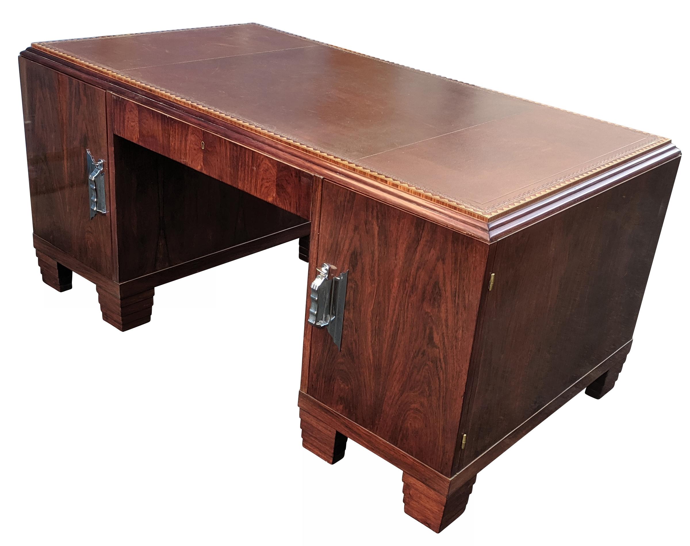 Per la tua considerazione c'è questa scrivania Partners degli anni '30 superbamente elegante. Il legno di base è mogano e impiallacciato in legno di noce di Bombay, con una calda tonalità rossastra e una leggera figurazione. Questa scrivania può