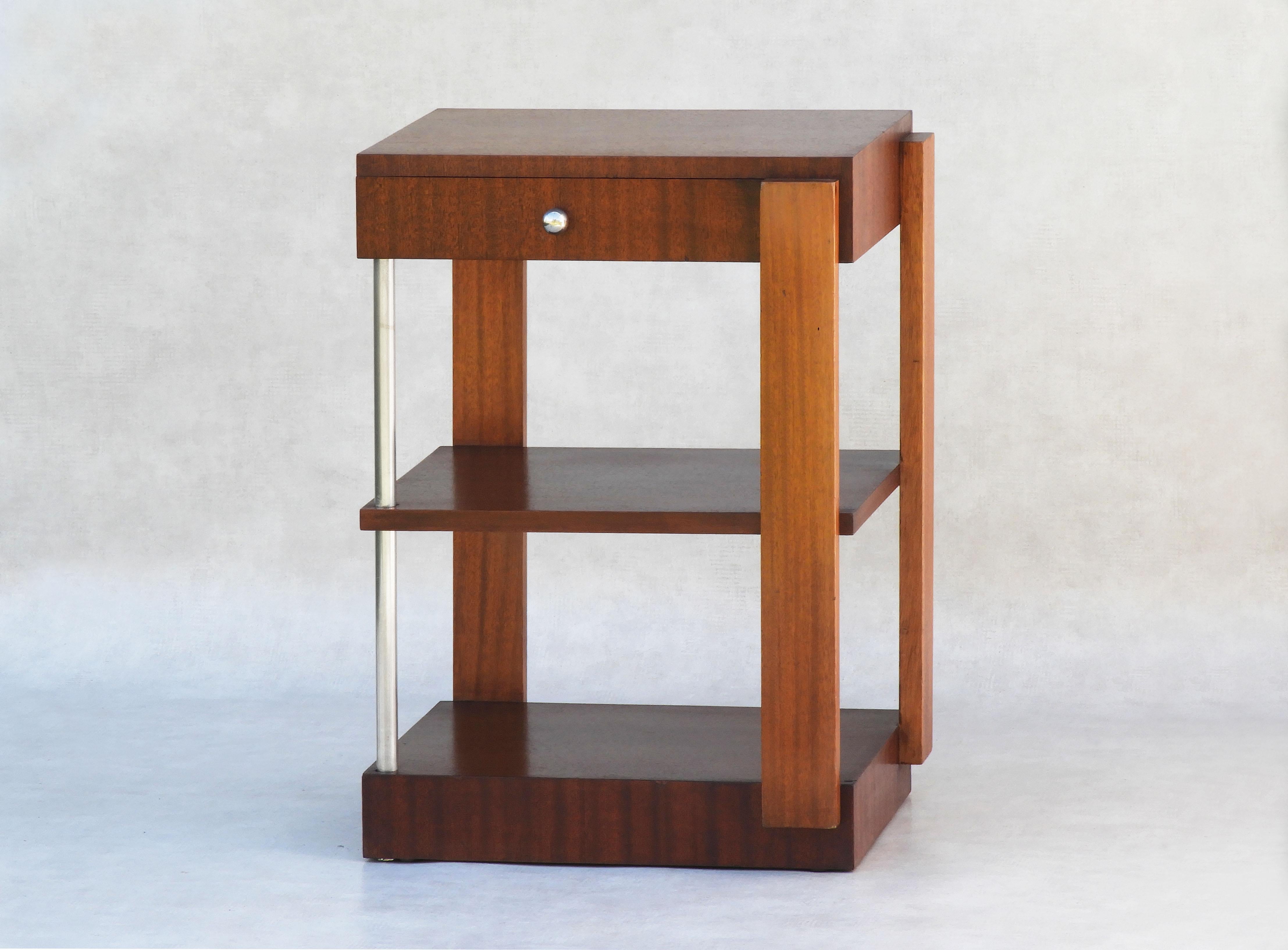 French Modernist Art Deco side table circa 1930.

A versatile three-tiered cabinet with a single drawer. Simple lines with silver hardware and a warm two-tone polished wood finish. This piece will sit easily in almost any room, finished on all