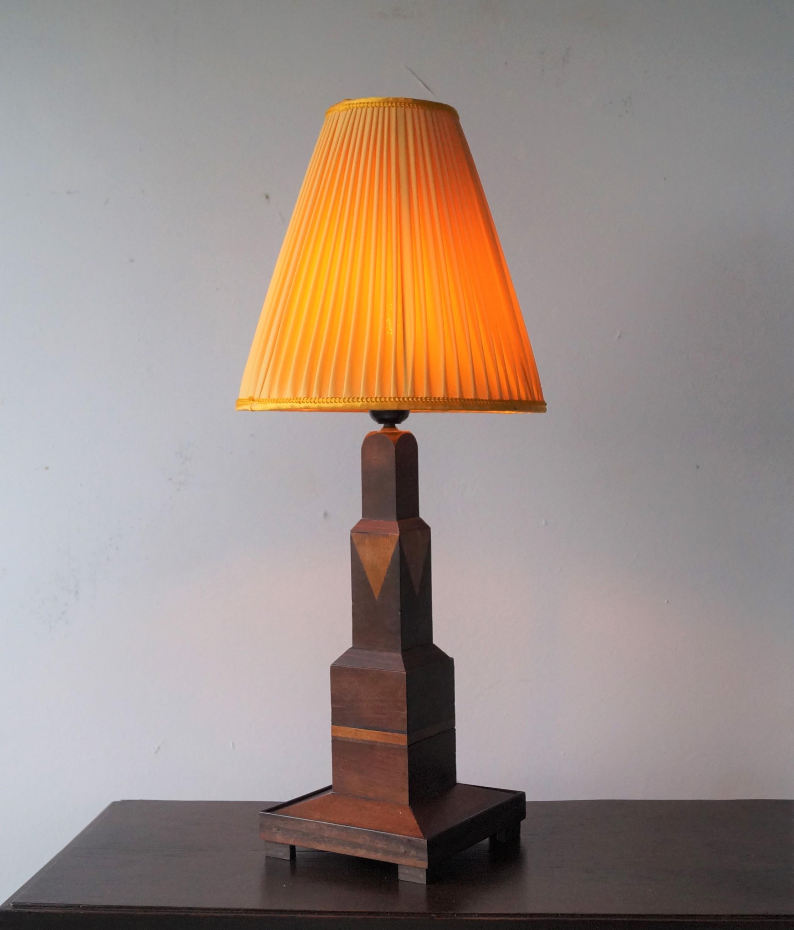 Unique and eye catching modernist table lamp, in a stepped design, entirely made of wood, mostly mahogany wood with inlay of teak and coromandel.
The pictures illustrate well how this lamp blends perfectly with modernist and art deco furniture. The