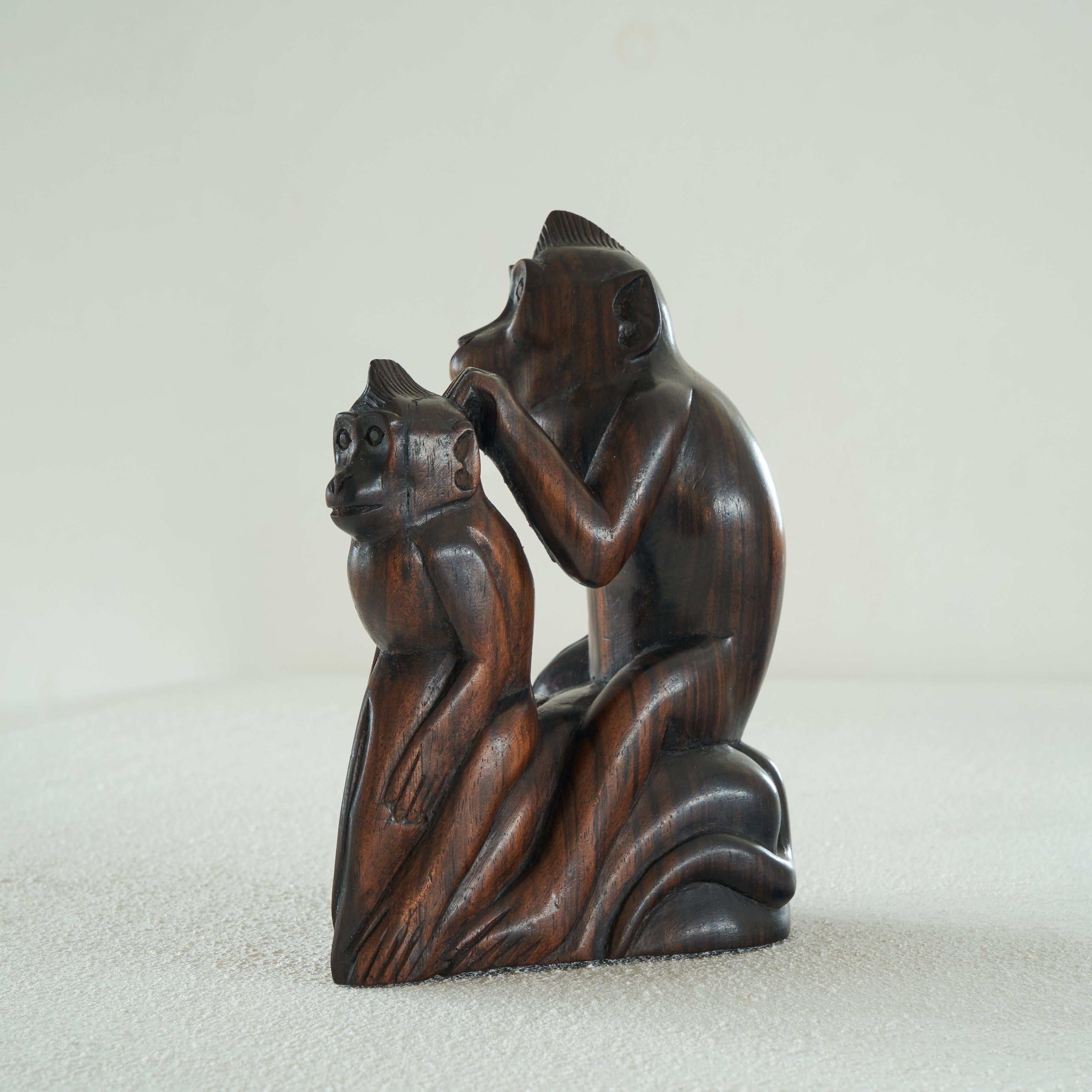Beautifully carved Art Deco figurine of two monkeys in tropical wood. First half of the 20th century. 

An adult monkey and a young monkey are seen in a dynamic and lifelike situation. This is a beautifully sculpted statue from all sides. The