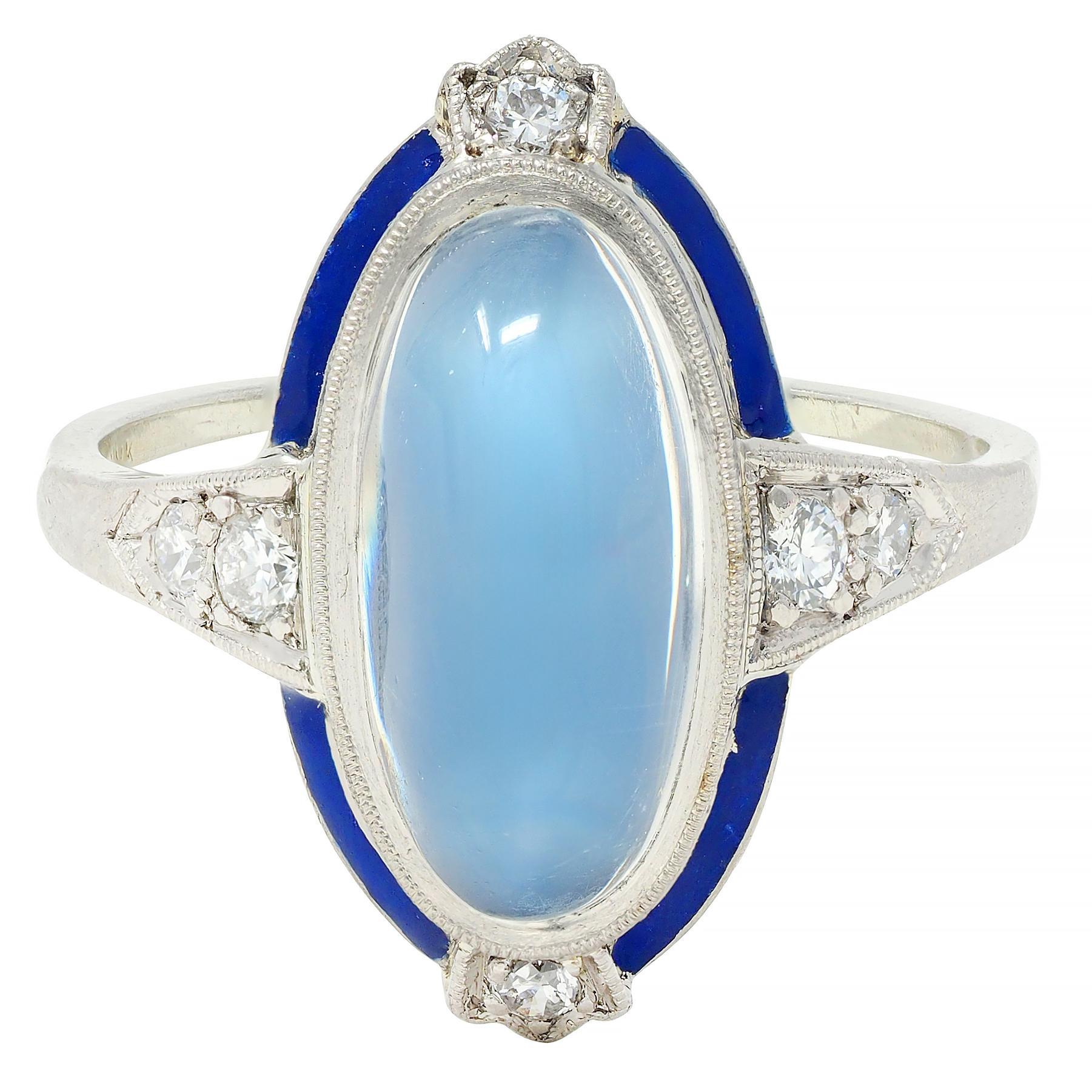 Centering an oval-shaped moonstone cabochon measuring 8.0 x 14.0 mm
Translucent colorless body displaying vivid blue adularescence 
Bezel set with a pierced halo surround of navy blue enamel
Glossed with minimal loss - accented by diamond