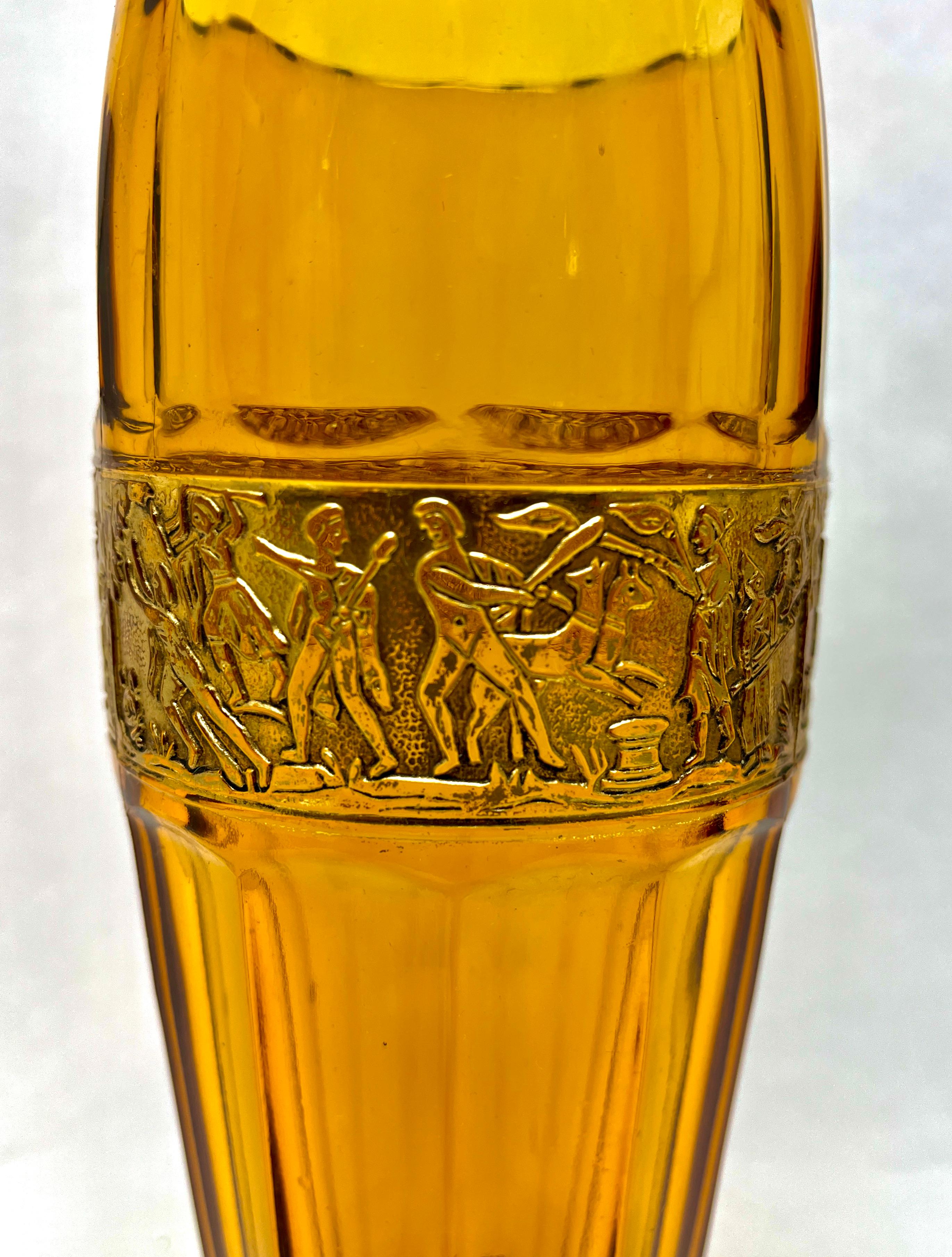 An Art Deco period etched amber glass vase by Leo Moser.
The flaring rim above a relief-cut panel highlighted in gilt, depicting Amazon warriors above a multi-faceted body.
The underside signed in script, ‘Moser, Carlsbad, made in Czechoslovakia’.