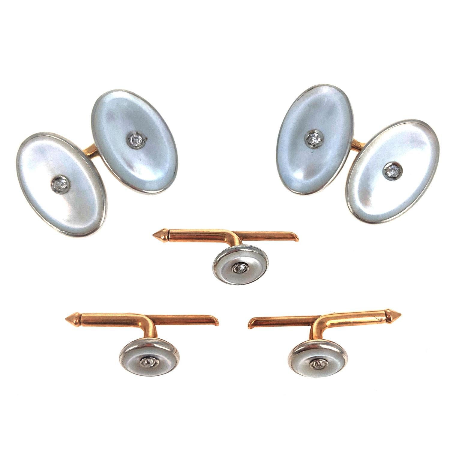 With cufflinks of oval plaques of mother-of-pearl centered around an old-European cut diamond and set in platinum and 1`4k yellow gold. Three buttons of the same design but round in shape. Circa 1920s. Each oval element is about 0.75 in and each