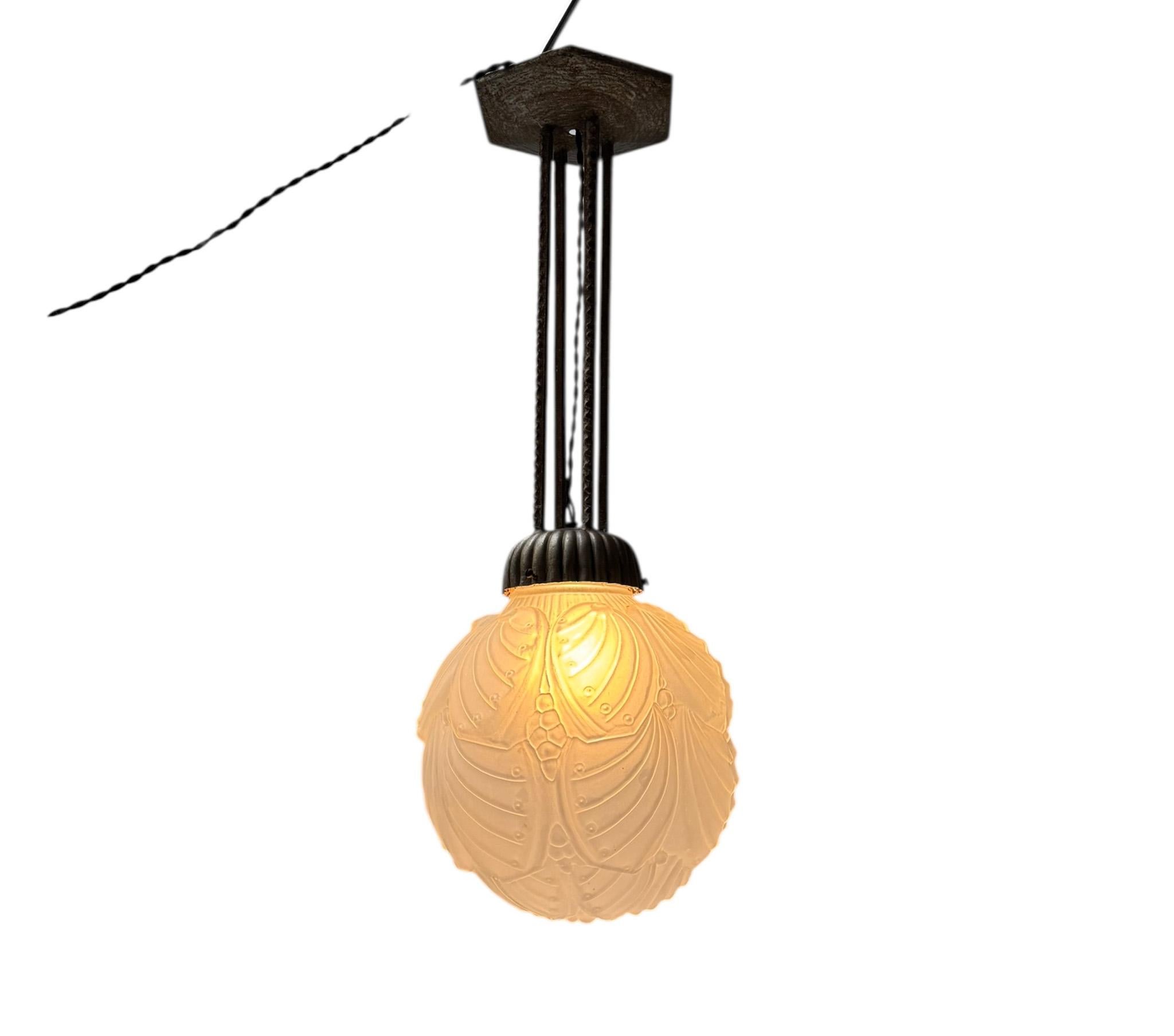 Splendida ed elegante lampada a sospensione in stile Art Déco.
Design nello stile di Muller Frères Luneville.
Un sorprendente design francese del 1930.
Cornice originale in metallo patinato con elementi decorativi.
L'originale paralume in vetro