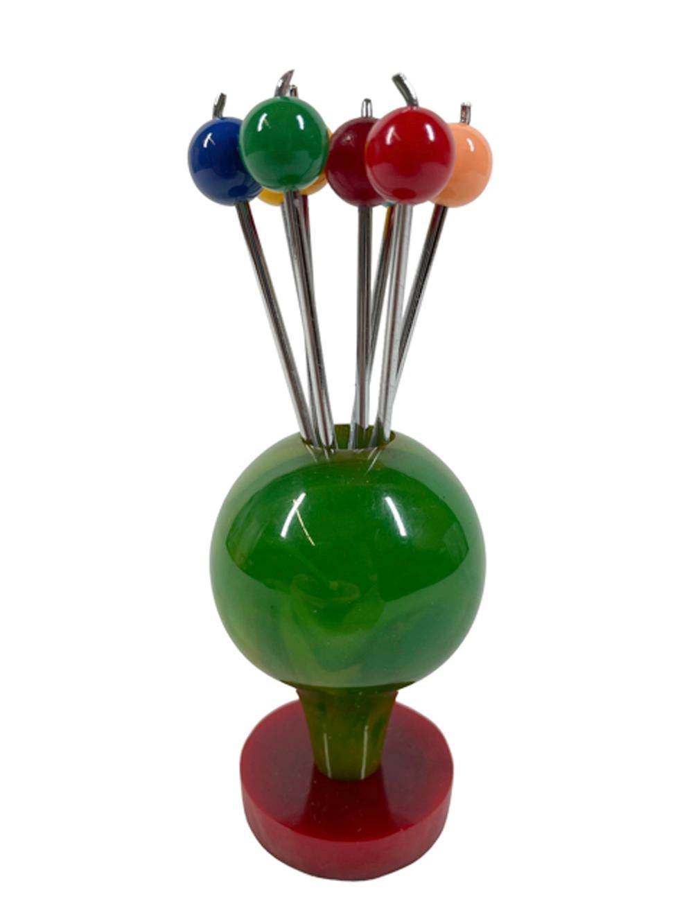 Art Deco Bakelite cocktail picks - eight forked chrome picks displayed as a bunch of balloons, each with a different color ball finial held in a mottled jade green balloon form stand rising from a red Bakelite disk-form base.