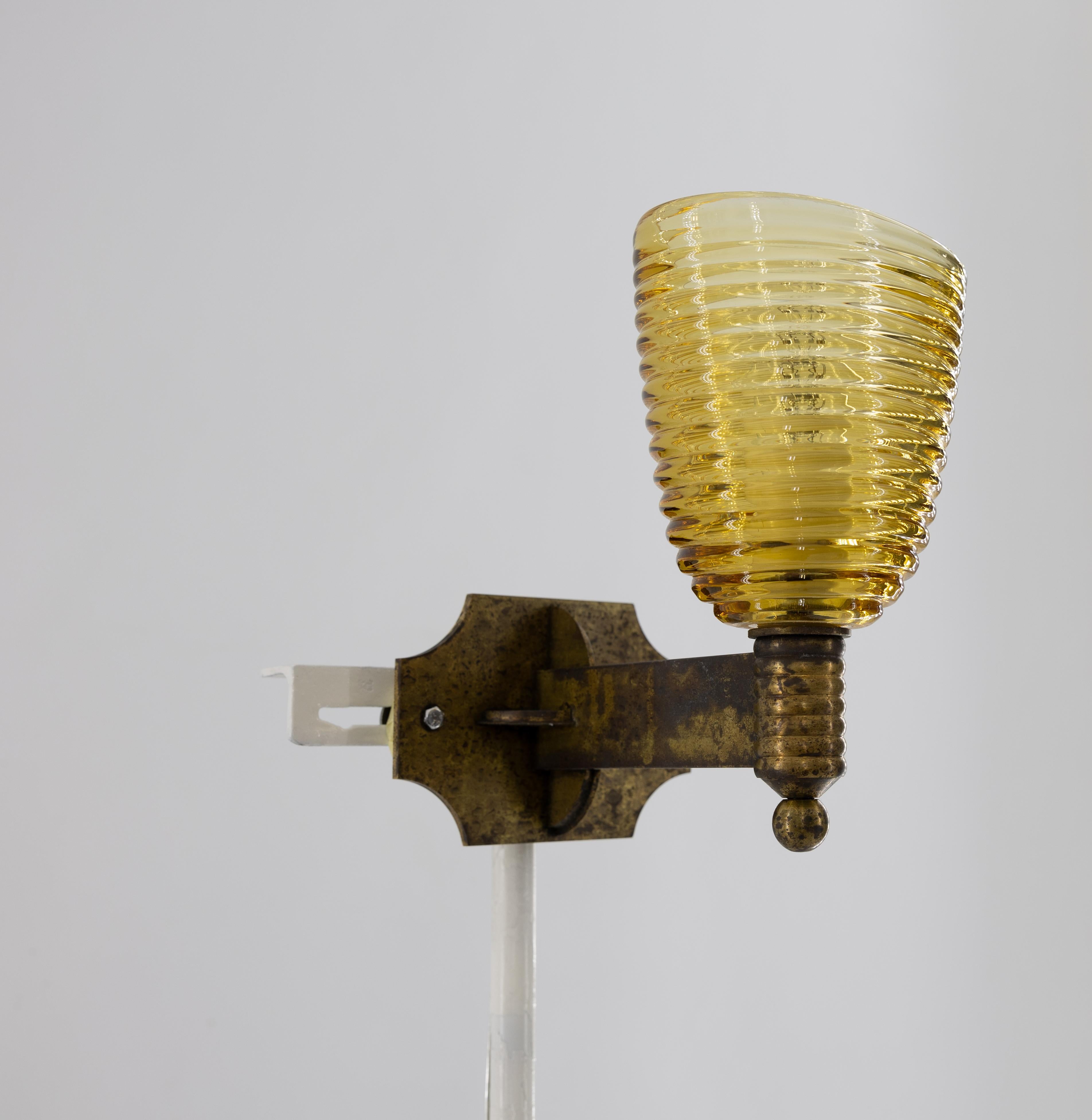 A Pair of Exquisite Art Deco Murano Glass Sconces in Amber and Brass, 1960s Italy.
This remarkable pair of Venetian sconces, masterfully crafted in the 1960s, epitomizes the artistry and craftsmanship of Murano glassmaking. Each sconce features an